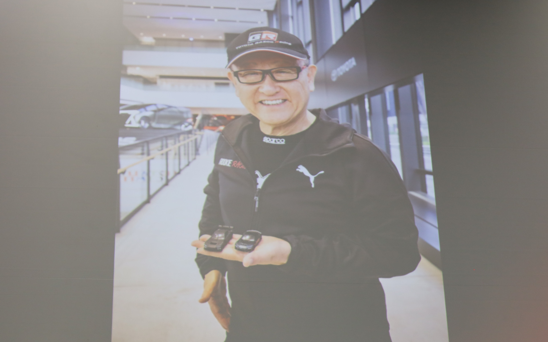 トヨタ自動車代表取締役会長 豊田章男氏がサンプル品を手にする写真が会場で披露された