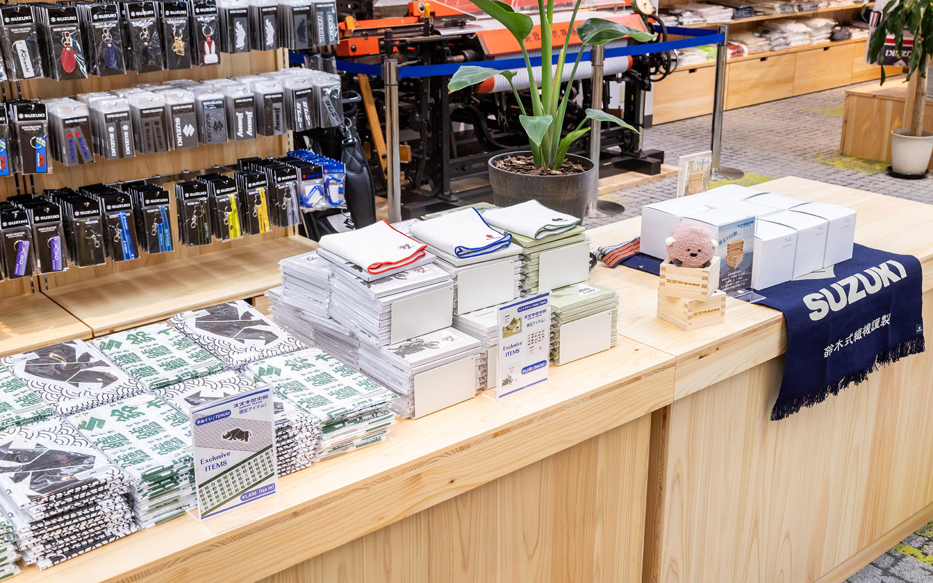 手ぬぐいやハンドタオルもスズキ歴史館限定アイテム。奥に見える箱は純正パーツの箱に見えるが、天竜ヒノキで作った「升」で100個限定のアイテムとなっている
