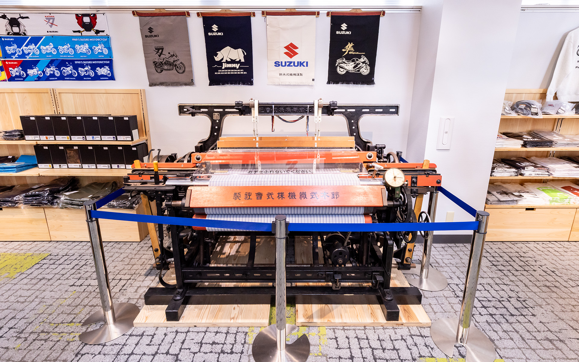 鈴木式織機も展示。後方に展示されている前かけは鈴木式織機で織ってある