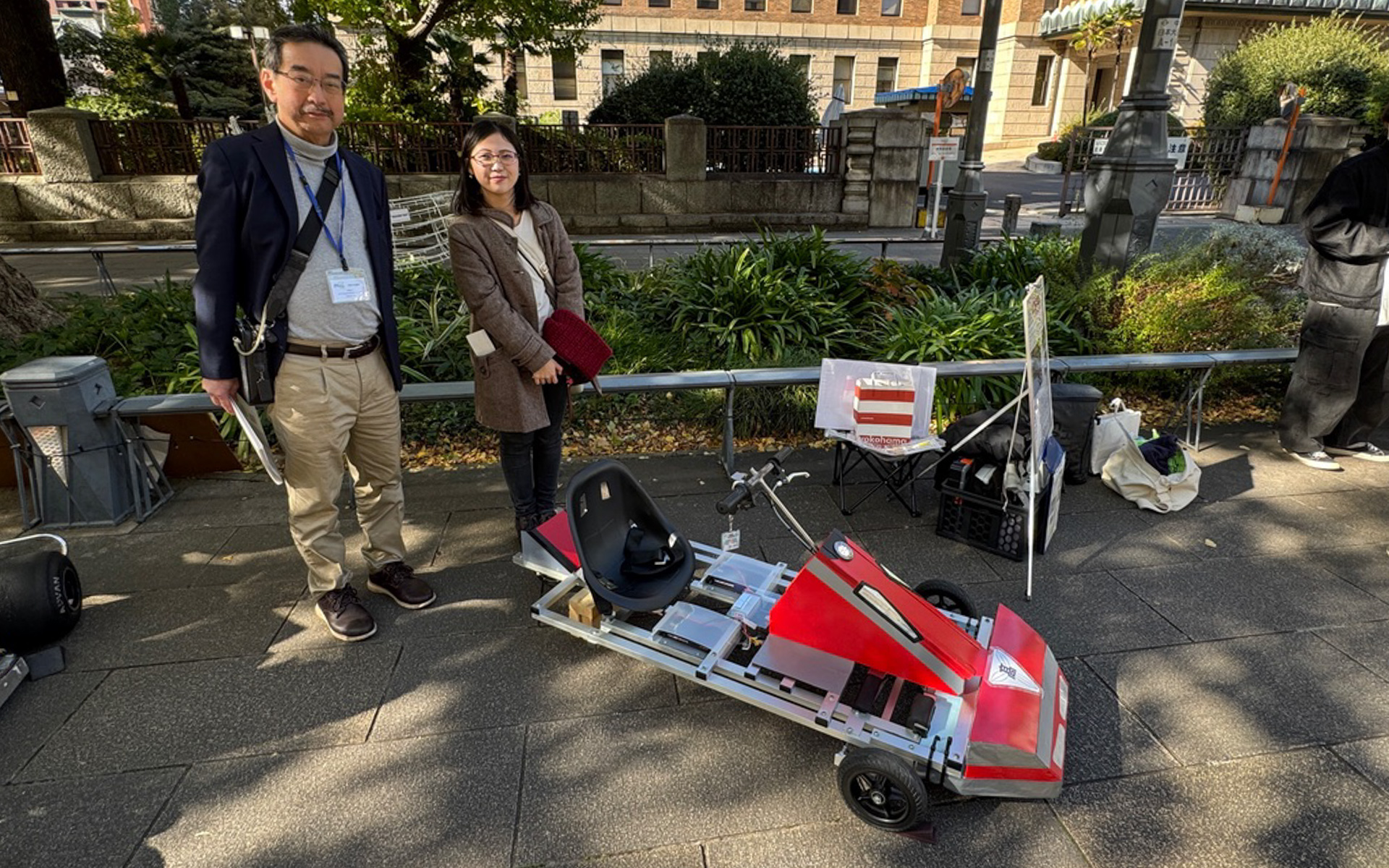 栃木県立鹿沼高等学校・サイエンス部・物理班の手作りEV展示は10年前に製作した「KPCEV-04」を進化させた「KPCEV-13」。10年前に製作を担当した学生さんだった森重比奈さん（右）は、今では大学の先生になっているそうです
