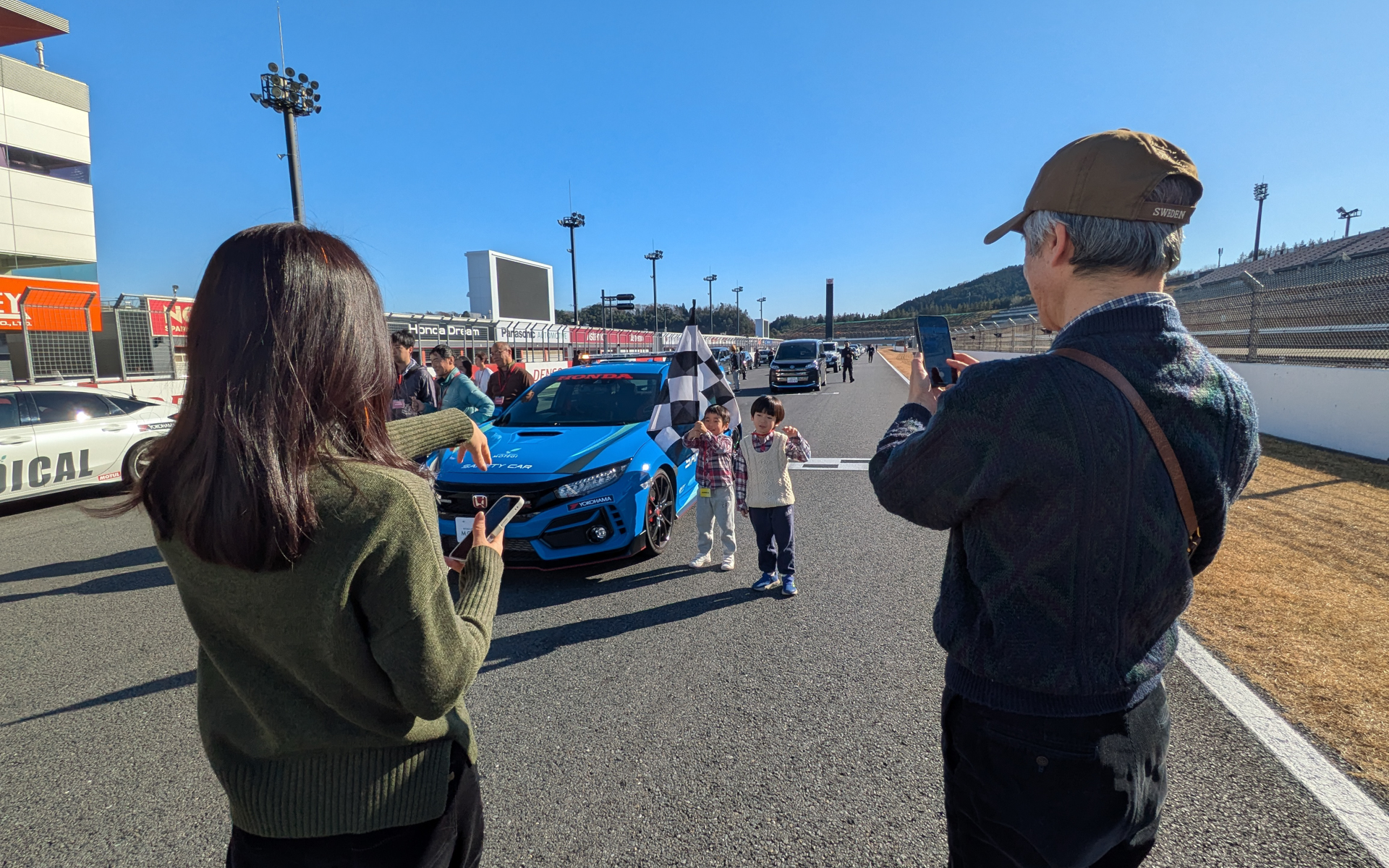 参加者はマーシャルカーと並んだり、レース用フラッグを持つなどして撮影を楽しんでいた