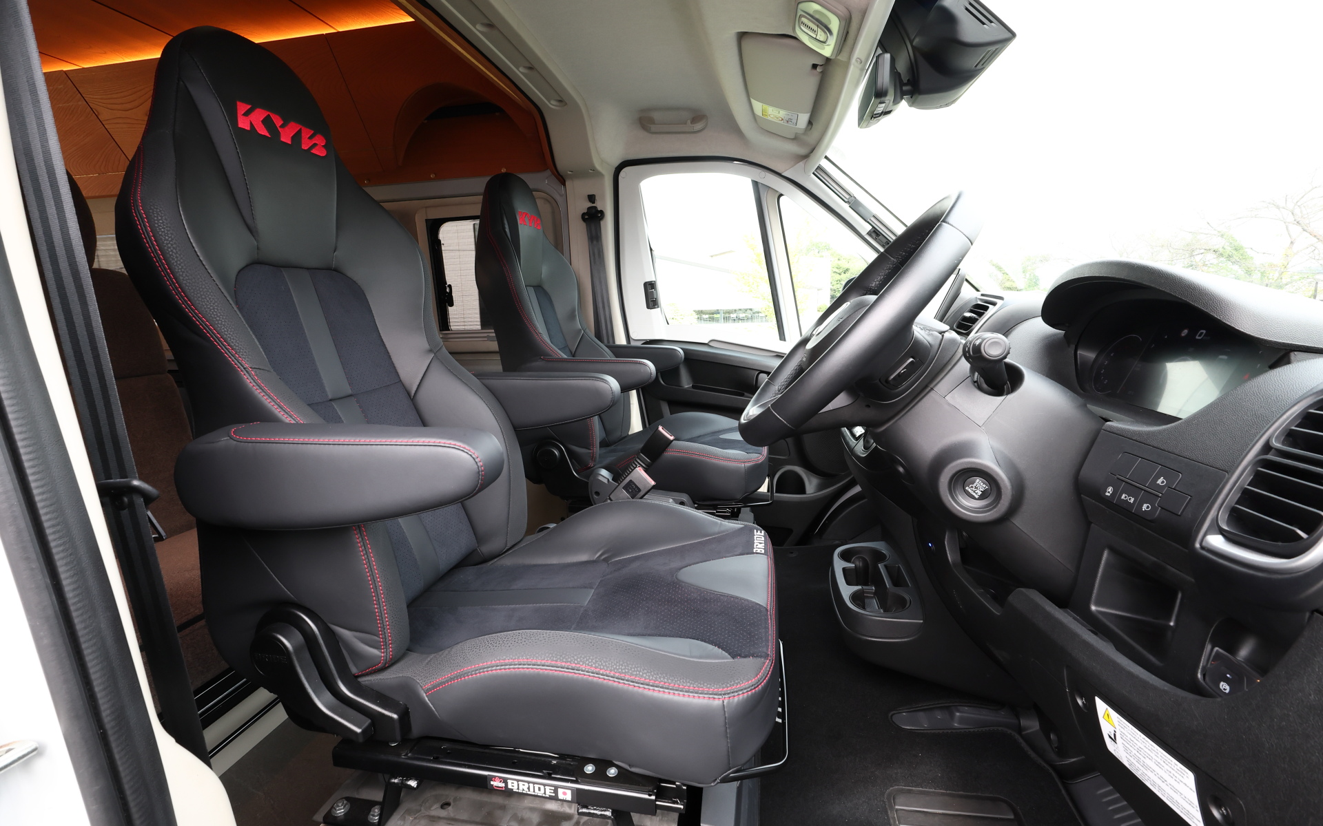 インテリアではブリッドと共同開発したキャンピングカー専用のバケットシートを運転席&助手席にセット。また“移動する別荘”を目指し、天然素材のケヤキの木目を生かしたデザインで上質感を演出する吊り戸棚、対面式のベンチソファー、ベンチソファーと組み合わせることで簡単にセットアップできるベッド(1800×1800mm)、大型のリアオープンデッキ、電子レンジと85Lの冷蔵庫を1か所にレイアウトしたキッチン、外部電源による充電と走行充電で電力を確保できるサブバッテリ(リン酸鉄リチウムイオン/5kWh)などを装備。タープやサンシェードなども付属する