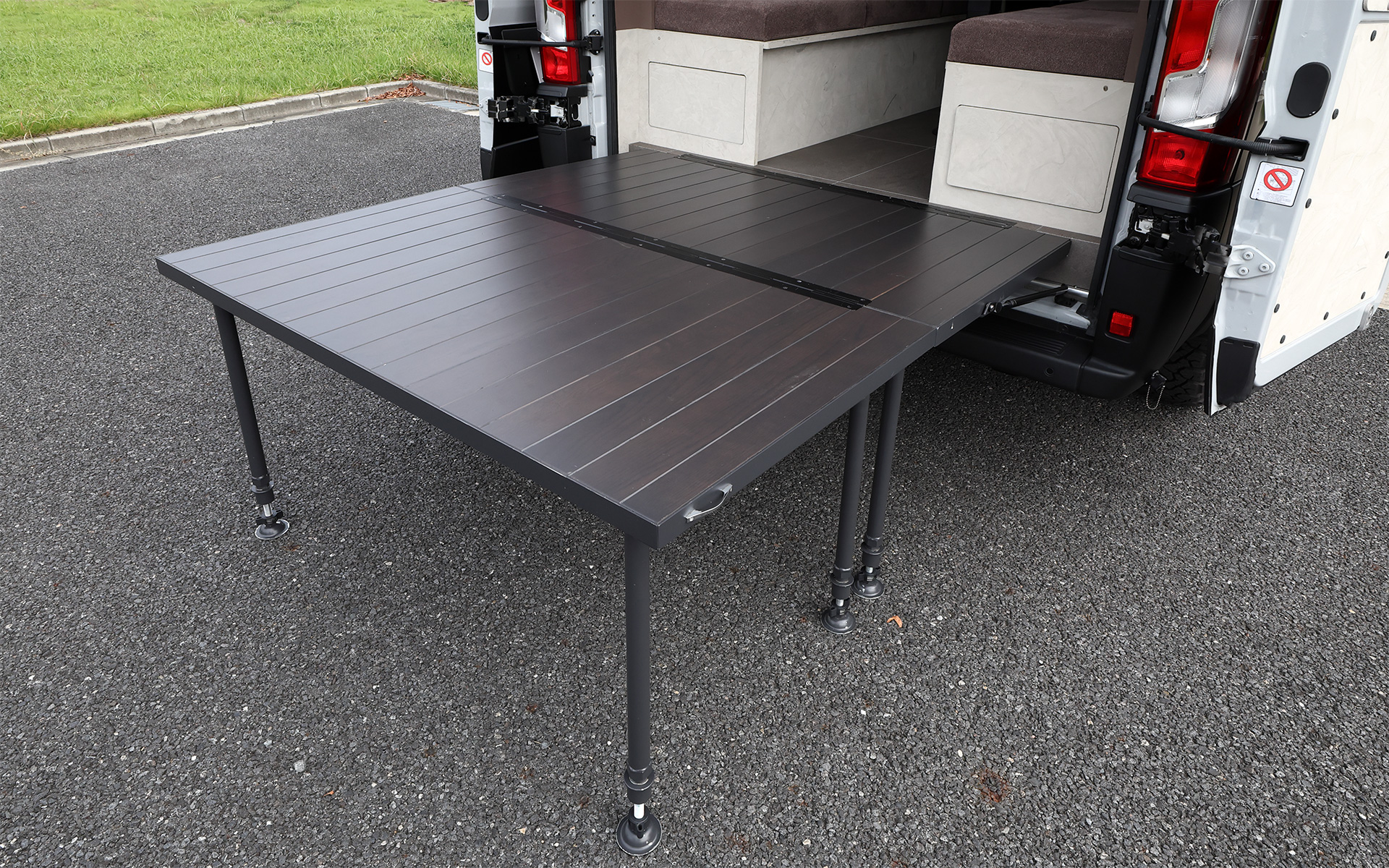 インテリアではブリッドと共同開発したキャンピングカー専用のバケットシートを運転席＆助手席にセット。また“移動する別荘”を目指し、天然素材のケヤキの木目を生かしたデザインで上質感を演出する吊り戸棚、対面式のベンチソファー、ベンチソファーと組み合わせることで簡単にセットアップできるベッド（1800×1800mm）、大型のリアオープンデッキ、電子レンジと85Lの冷蔵庫を1か所にレイアウトしたキッチン、外部電源による充電と走行充電で電力を確保できるサブバッテリ（リン酸鉄リチウムイオン/5kWh）などを装備。タープやサンシェードなども付属する