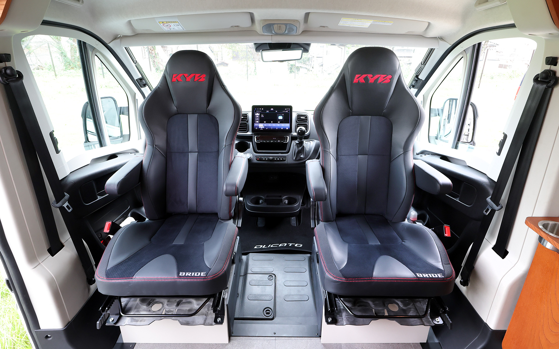 インテリアではブリッドと共同開発したキャンピングカー専用のバケットシートを運転席＆助手席にセット。また“移動する別荘”を目指し、天然素材のケヤキの木目を生かしたデザインで上質感を演出する吊り戸棚、対面式のベンチソファー、ベンチソファーと組み合わせることで簡単にセットアップできるベッド（1800×1800mm）、大型のリアオープンデッキ、電子レンジと85Lの冷蔵庫を1か所にレイアウトしたキッチン、外部電源による充電と走行充電で電力を確保できるサブバッテリ（リン酸鉄リチウムイオン/5kWh）などを装備。タープやサンシェードなども付属する