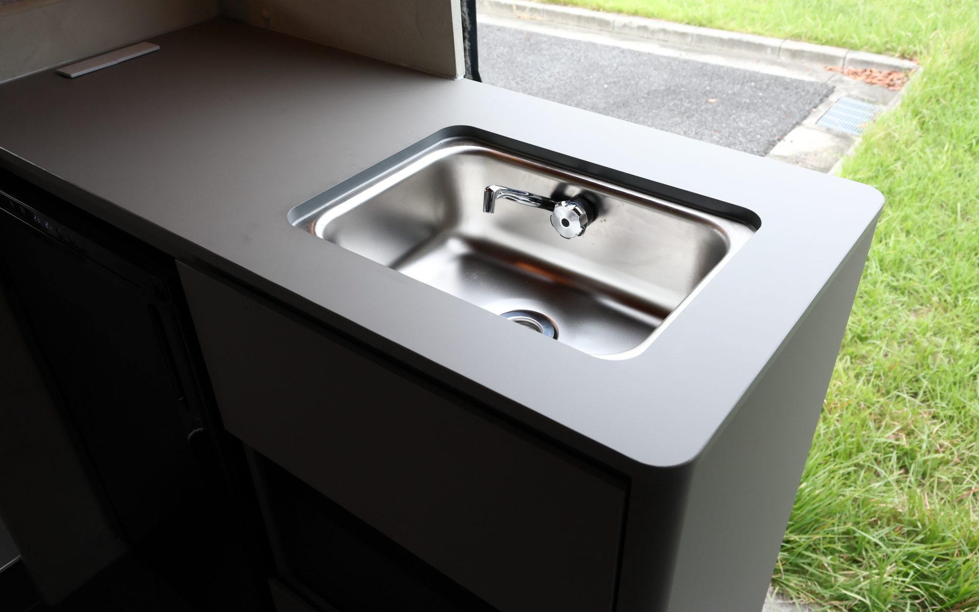 インテリアではブリッドと共同開発したキャンピングカー専用のバケットシートを運転席＆助手席にセット。また“移動する別荘”を目指し、天然素材のケヤキの木目を生かしたデザインで上質感を演出する吊り戸棚、対面式のベンチソファー、ベンチソファーと組み合わせることで簡単にセットアップできるベッド（1800×1800mm）、大型のリアオープンデッキ、電子レンジと85Lの冷蔵庫を1か所にレイアウトしたキッチン、外部電源による充電と走行充電で電力を確保できるサブバッテリ（リン酸鉄リチウムイオン/5kWh）などを装備。タープやサンシェードなども付属する