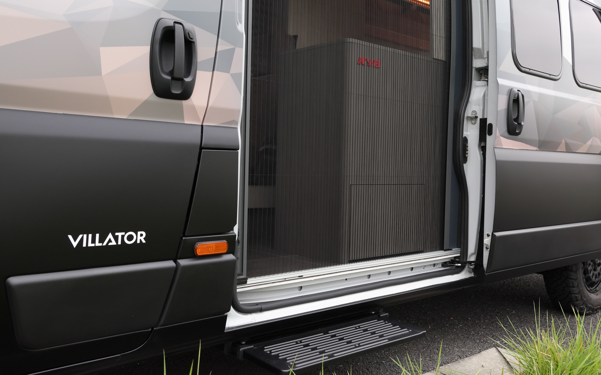 インテリアではブリッドと共同開発したキャンピングカー専用のバケットシートを運転席＆助手席にセット。また“移動する別荘”を目指し、天然素材のケヤキの木目を生かしたデザインで上質感を演出する吊り戸棚、対面式のベンチソファー、ベンチソファーと組み合わせることで簡単にセットアップできるベッド（1800×1800mm）、大型のリアオープンデッキ、電子レンジと85Lの冷蔵庫を1か所にレイアウトしたキッチン、外部電源による充電と走行充電で電力を確保できるサブバッテリ（リン酸鉄リチウムイオン/5kWh）などを装備。タープやサンシェードなども付属する