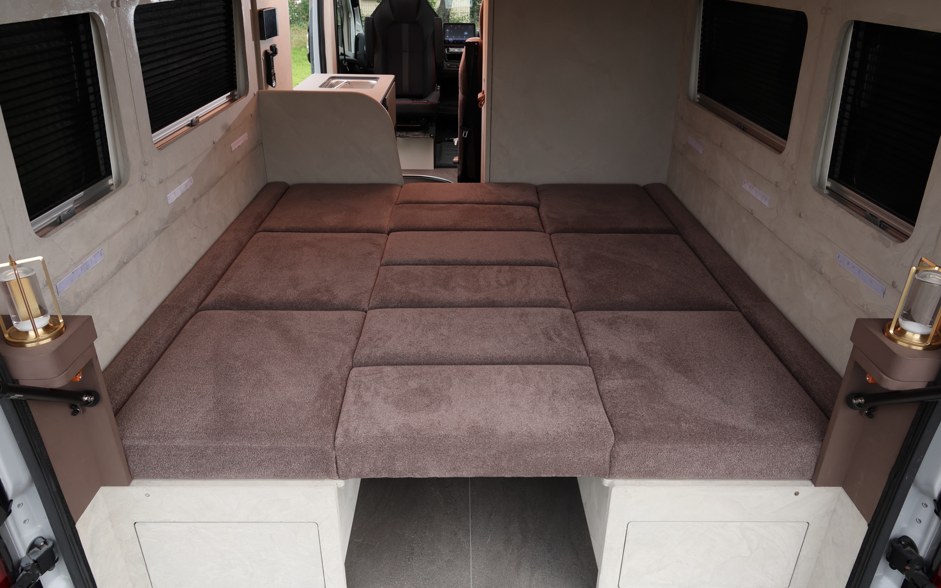 インテリアではブリッドと共同開発したキャンピングカー専用のバケットシートを運転席&助手席にセット。また“移動する別荘”を目指し、天然素材のケヤキの木目を生かしたデザインで上質感を演出する吊り戸棚、対面式のベンチソファー、ベンチソファーと組み合わせることで簡単にセットアップできるベッド(1800×1800mm)、大型のリアオープンデッキ、電子レンジと85Lの冷蔵庫を1か所にレイアウトしたキッチン、外部電源による充電と走行充電で電力を確保できるサブバッテリ(リン酸鉄リチウムイオン/5kWh)などを装備。タープやサンシェードなども付属する