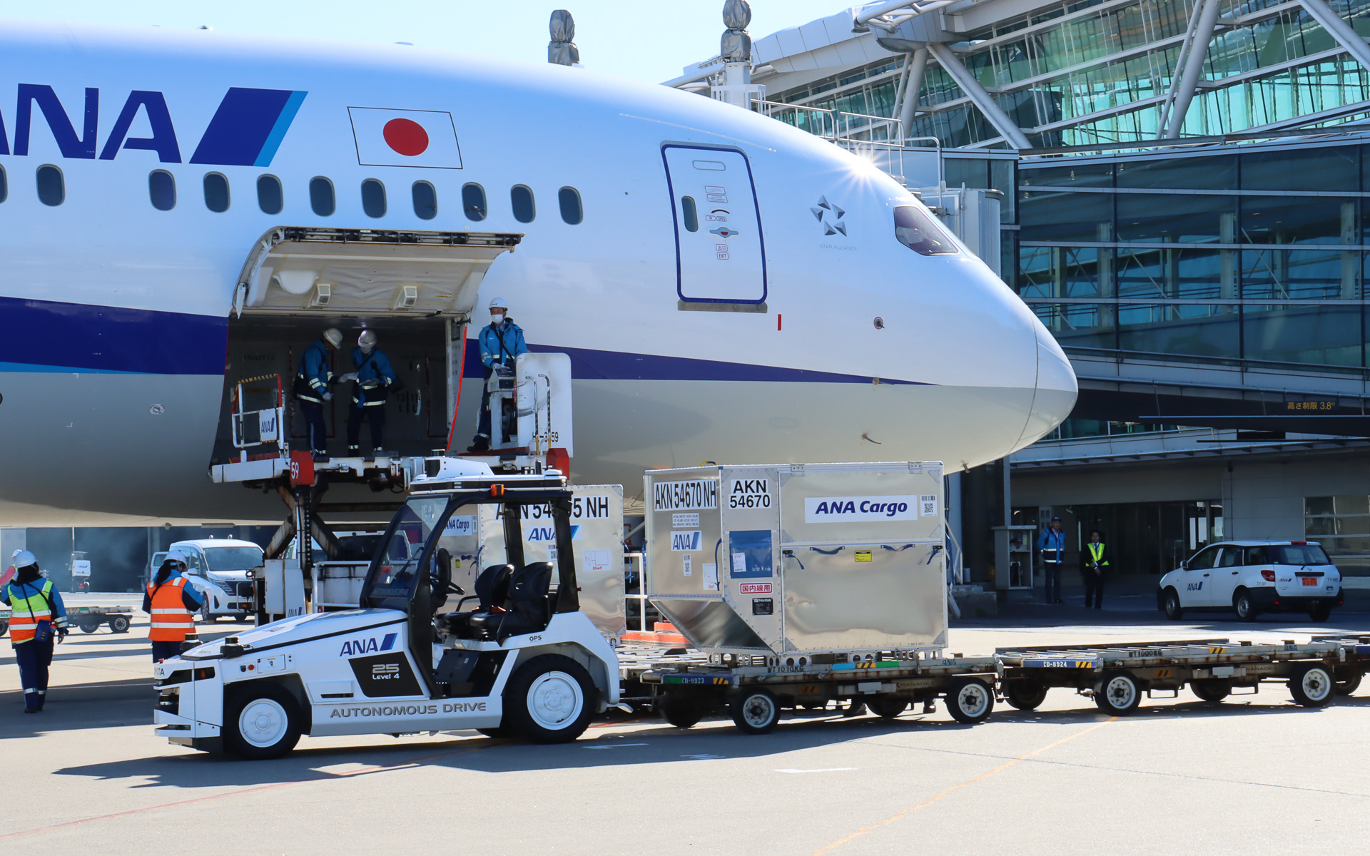 スタッフが飛行機に隣接する位置まで手動運転し、貨物が手際よく降ろされていく