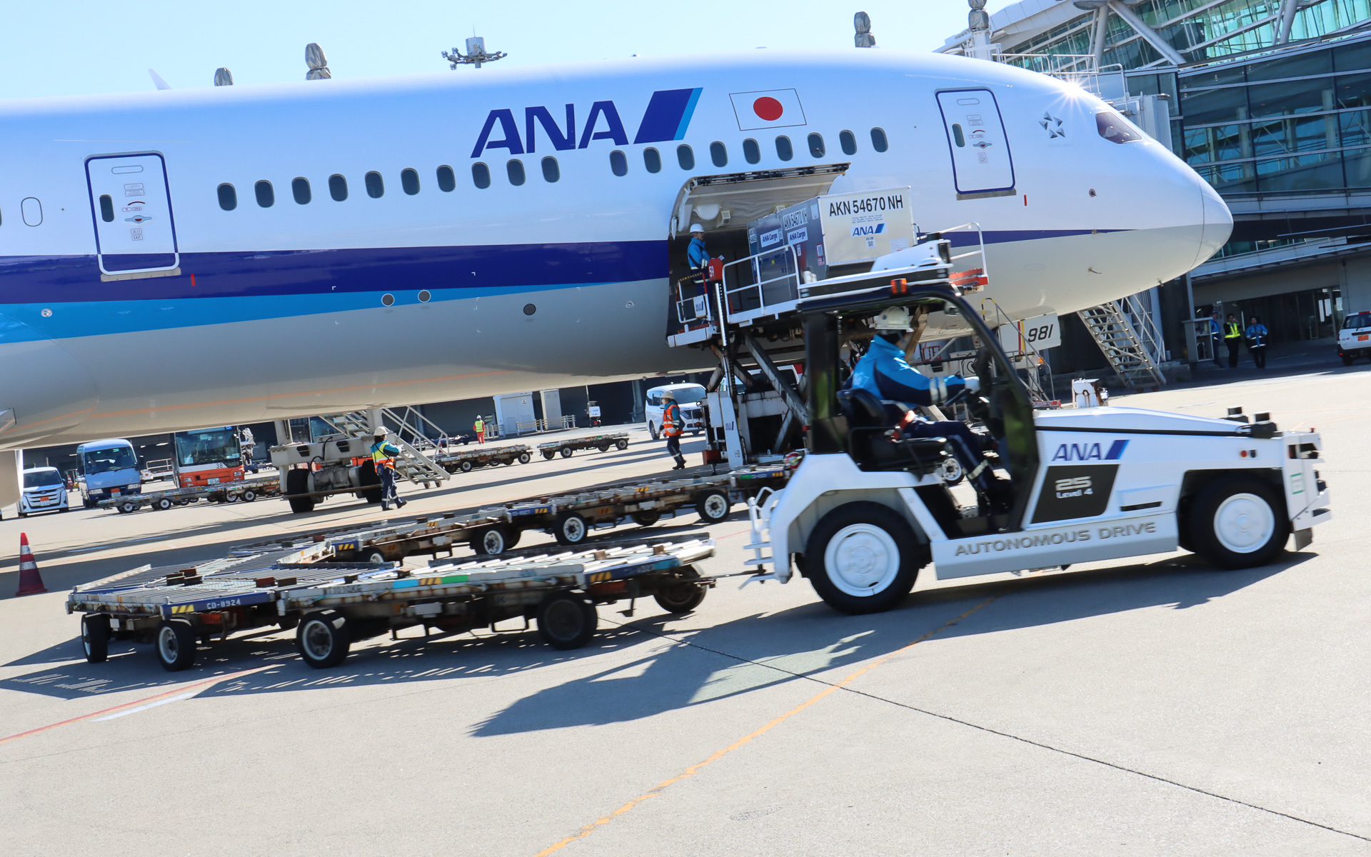 貨物を降ろしたらスタッフが通路際まで運転して、自動運転を再開させて国内貨物上屋まで戻っていった