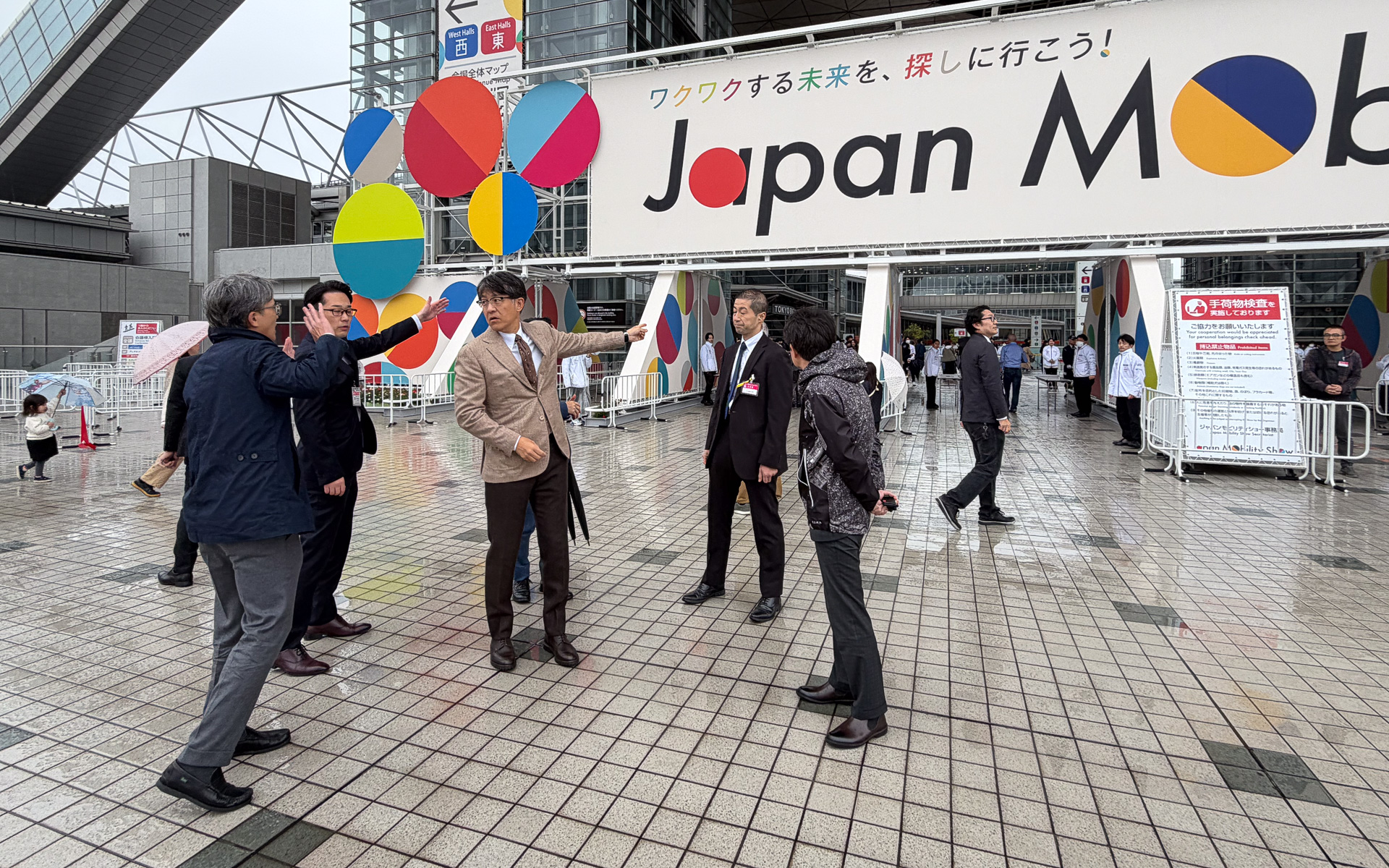 モビリティショーで観客の待機列が雨に濡れているのを見かねて、直しに入った佐藤恒治 自工会 副会長