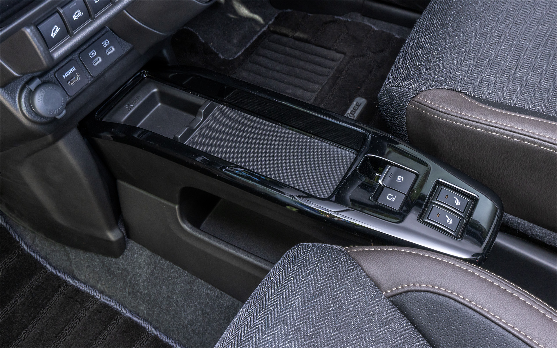 2段式のセンターコンソールや、センターコンソールアッパートレー、大型のドリンクホルダーなど、使い勝手のよい収納を多く備える。HYBRID MZのアップグレードパッケージ装着車はカラーがサファリカーキとなるドアパネルやインパネには、肌触りのよさそうなレザー素材が用いられているように見えるが、実は樹脂製。革だと思って触ると固くてびっくりする