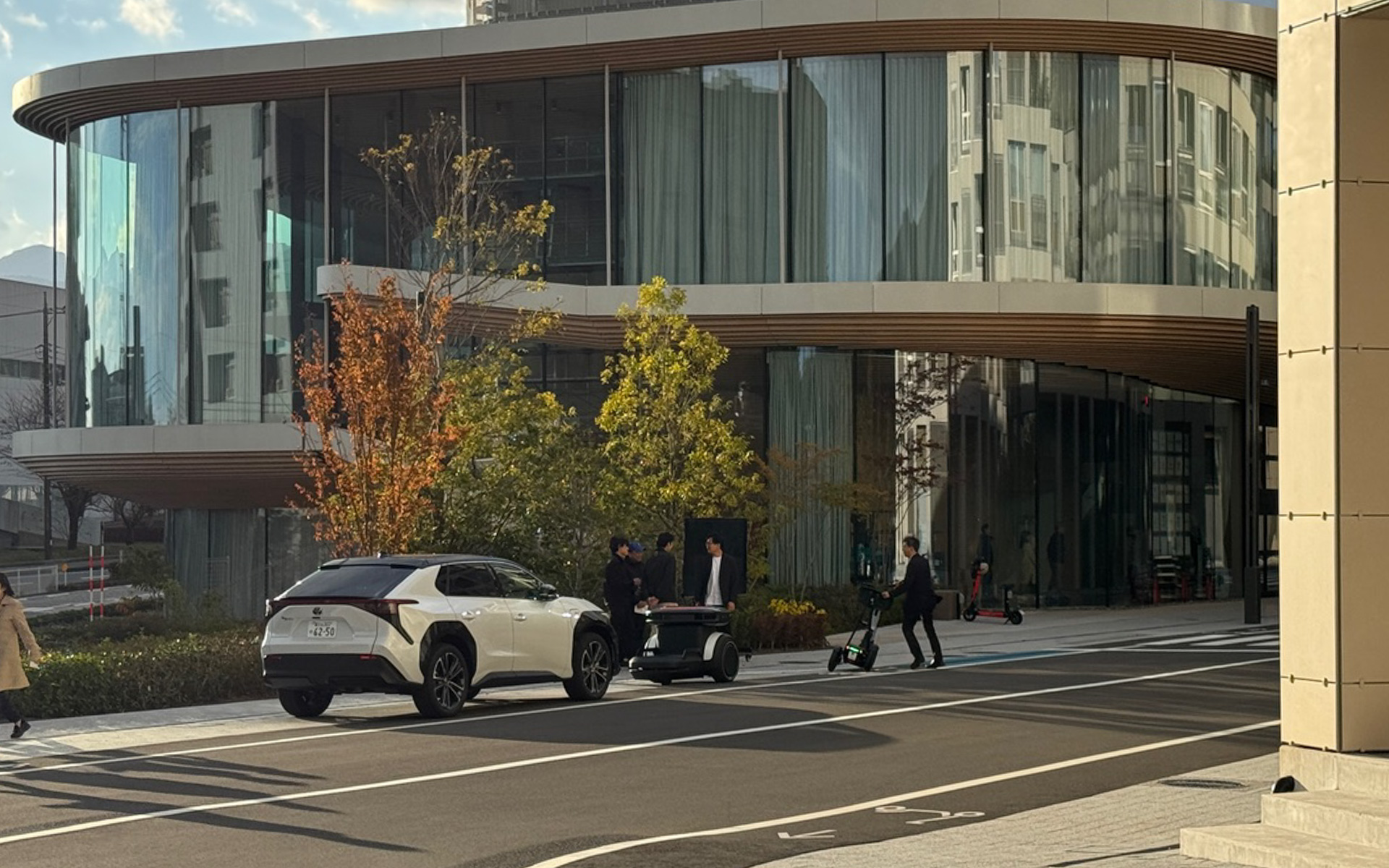 カーシェア車両のbZ4Xの前にある小さなモビリティが、新たなカーシェアサービスの鍵となる自律走行ロボット「ガイドモビ」です