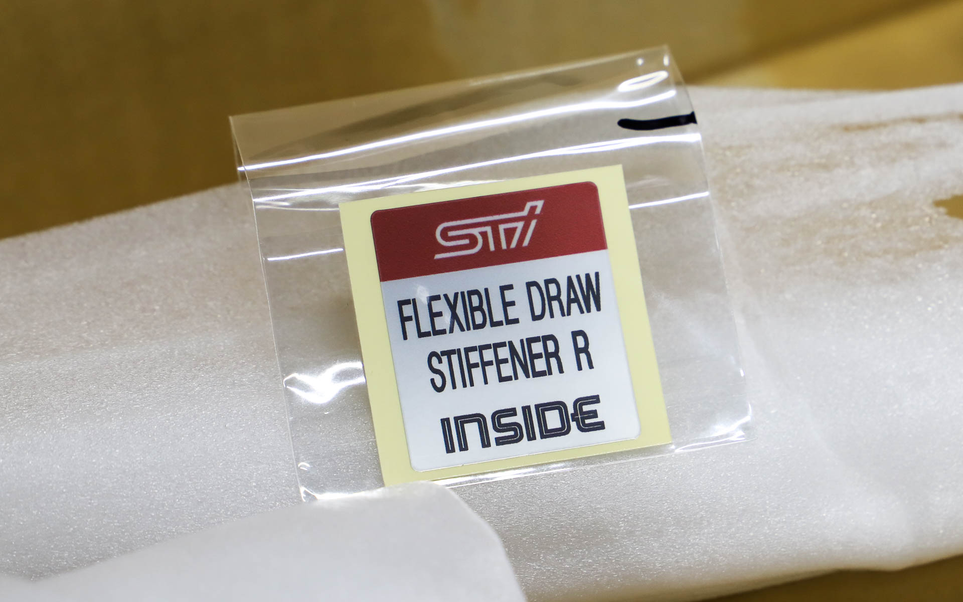 取り付けパーツはリアバンパーの裏側（内側）になるので、隠れてしまって見た目にはわからない。ということで、装着していることを示すステッカーが付属する