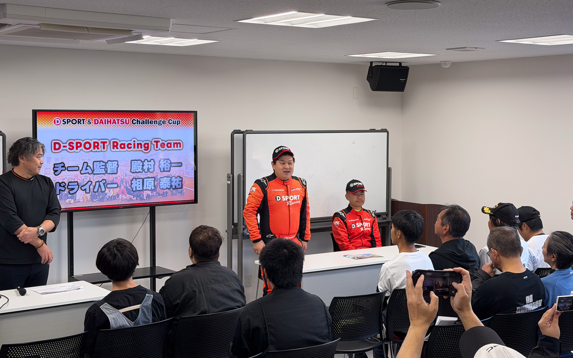 開会式であいさつするドライバーの相原泰裕選手（中央）と、チーム監督 殿村裕一氏（右）