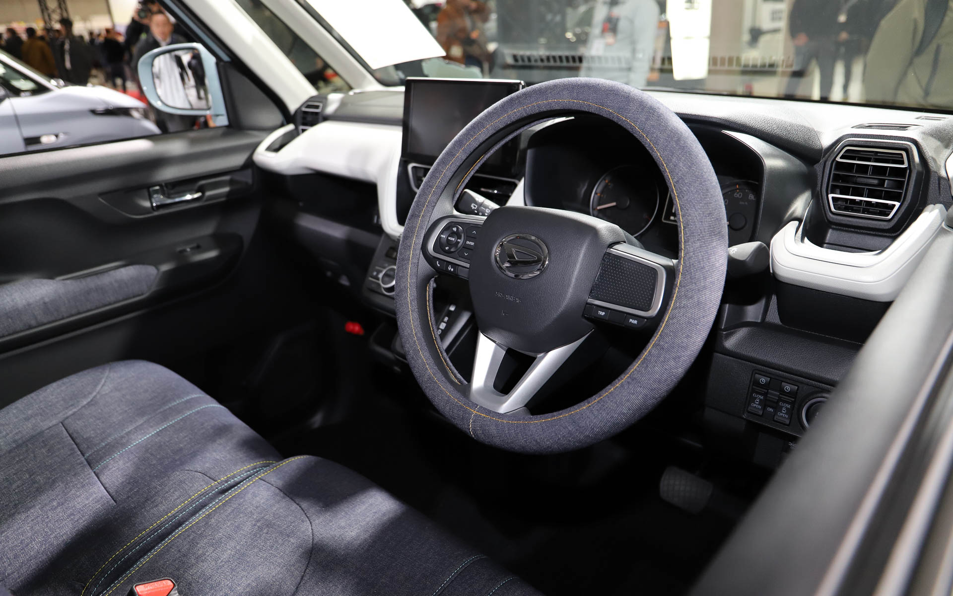 ちらりとこちらを見ているダイハツロゴのタグが付いたテディベアが愛らしい。内装はデニム調でまとめられていて軽やか