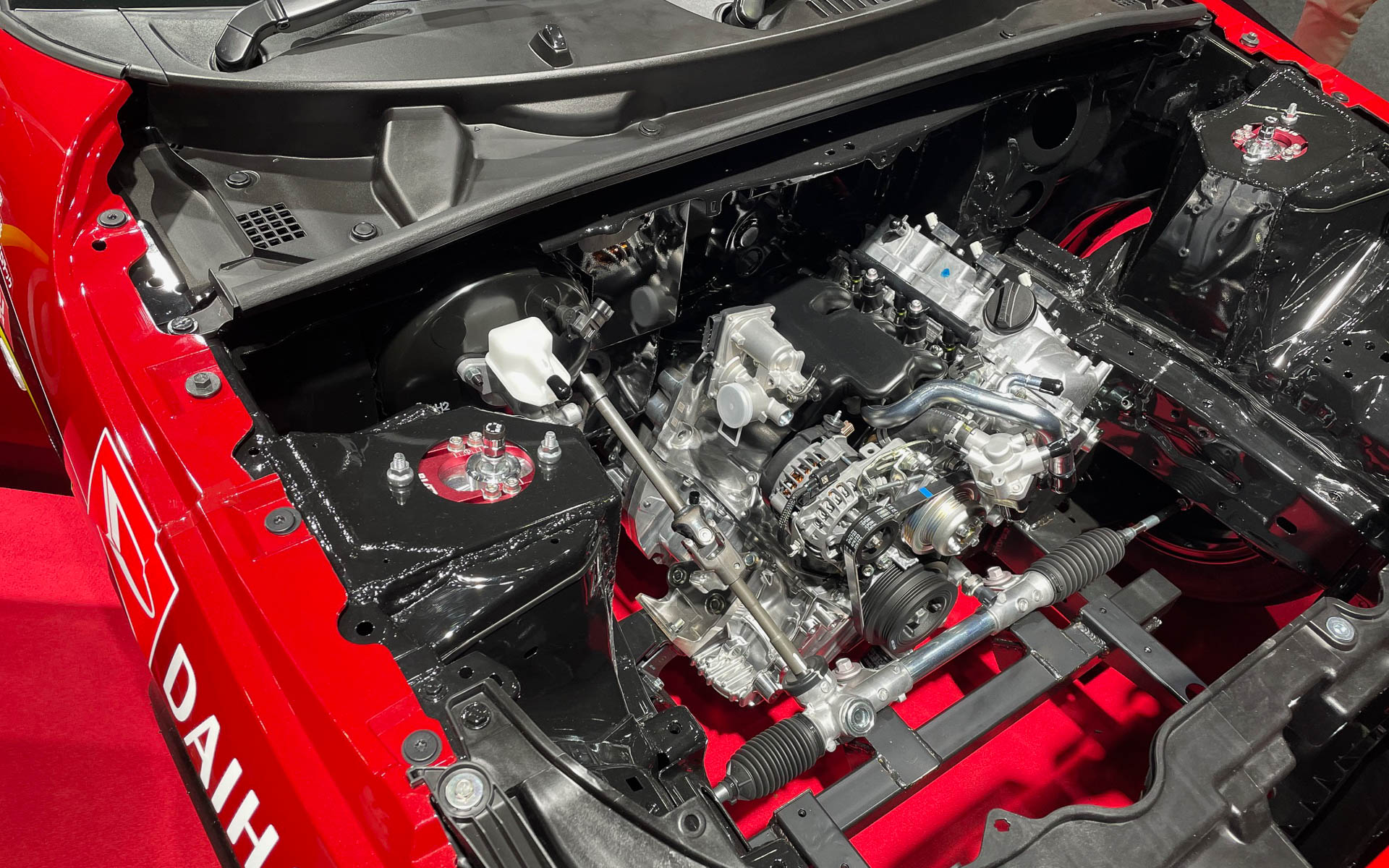 K-OPENランニングプロト2。つまり横置き3気筒を縦置きにしたフロントミッドシップのFR。エンジンルームはスカスカだ。いずれにしても人もクルマもクーリング対策がポイントだと思う