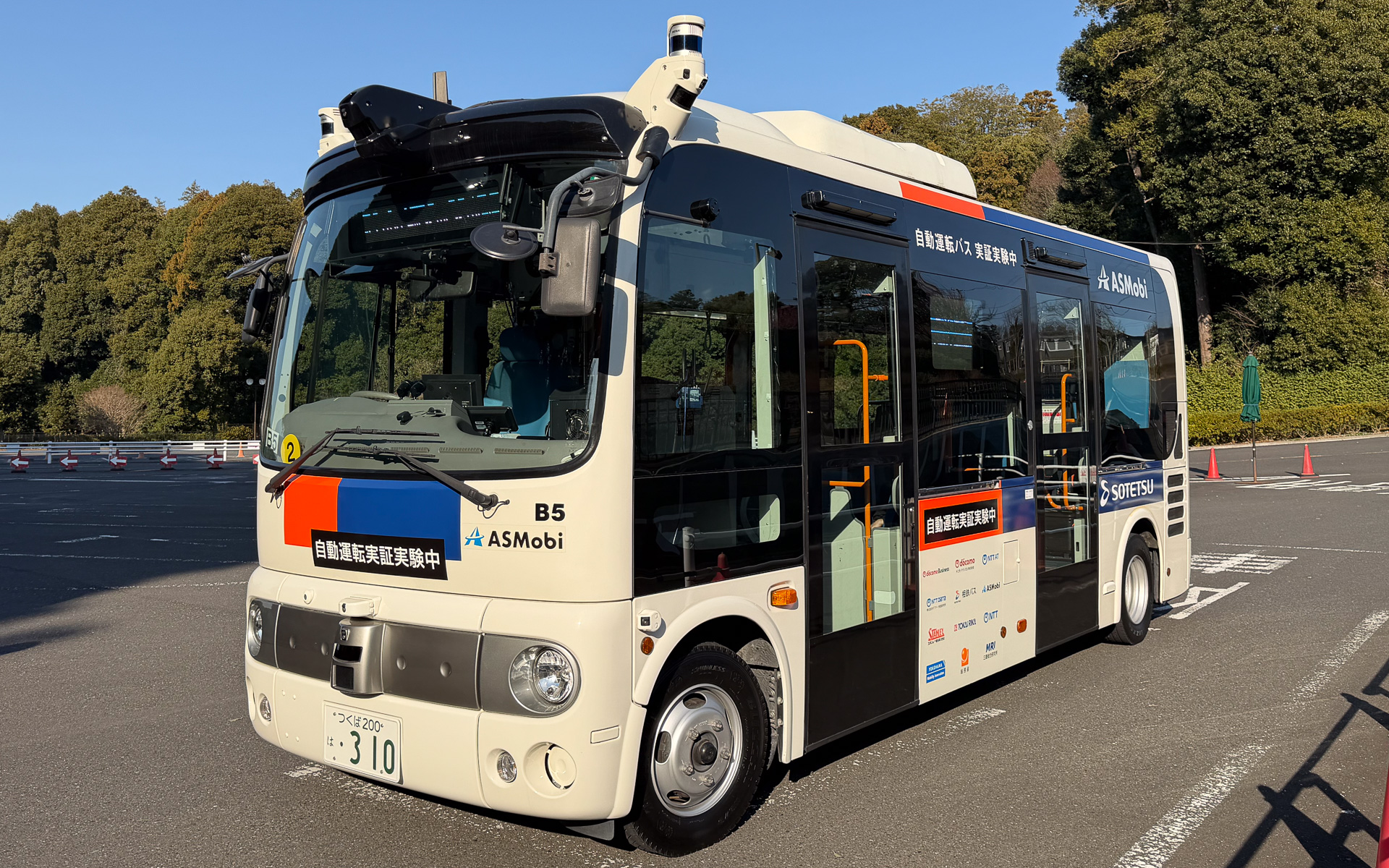 自動運転の実証実験に用いられる日野ポンチョ。8つのLiDAR、10のカメラで周囲を認識する。自動運転の部分は先進モビリティ、通信をNTTドコモビジネスが提供