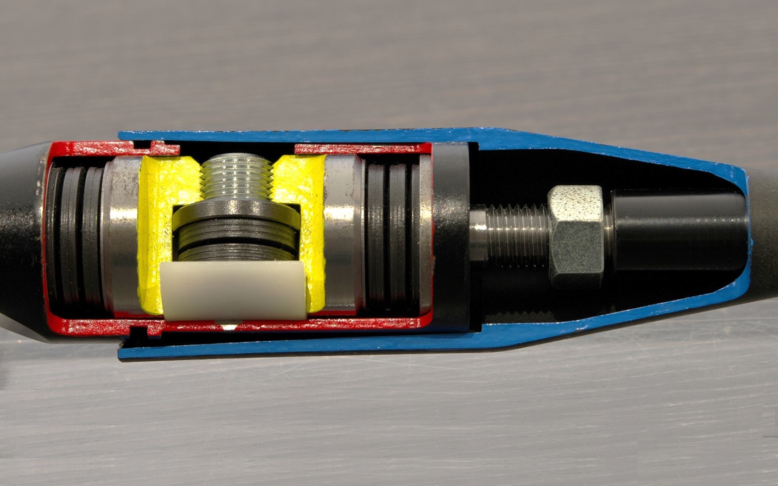 MCBの内部。赤色のスチールケースの左右に、縦方向に収まっているのがボディが変形するような荷重（入力）と同等の反力を発生させるスプリング。黄色の部分の下側にある白い物体が樹脂で、上からネジを締め込むことでスチールケースとの摩擦が発生し、微振動を吸収してくれる