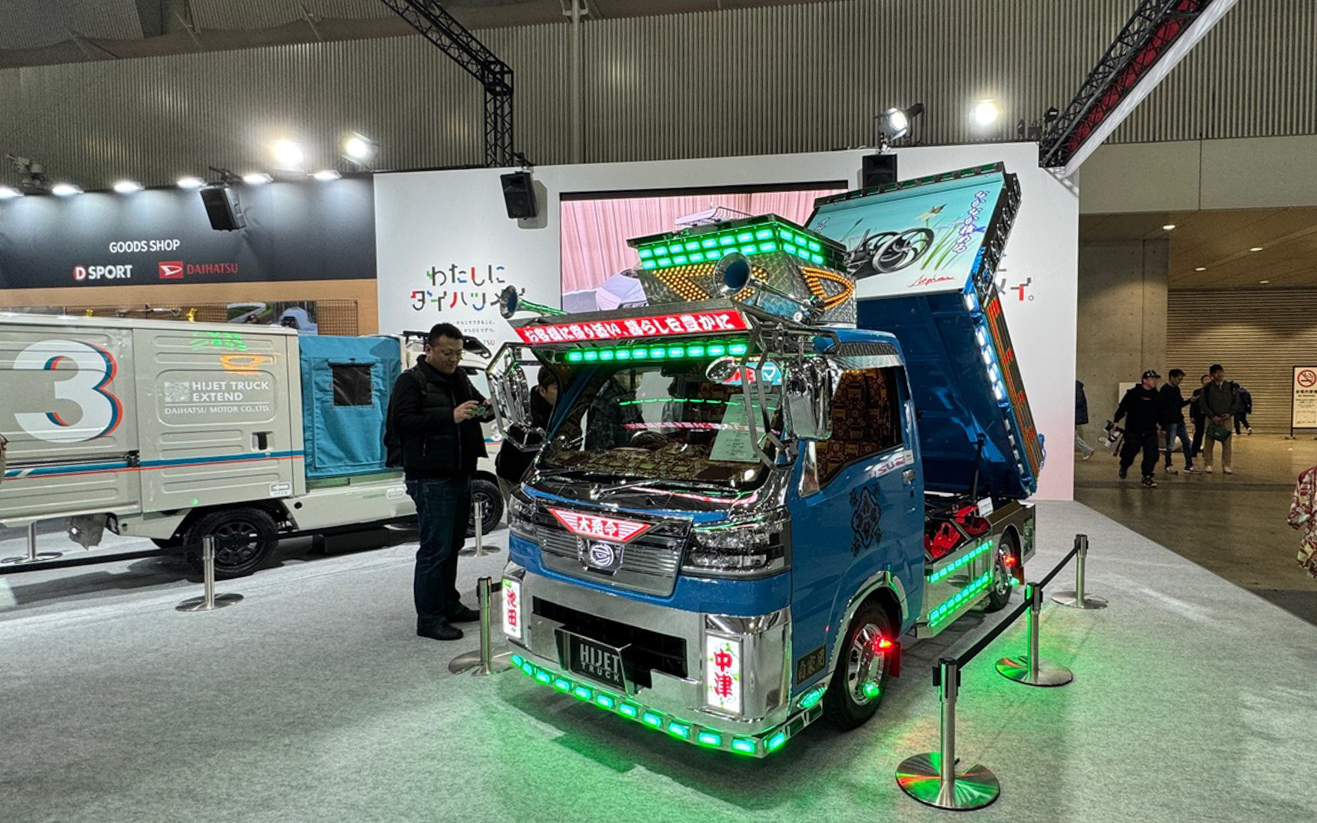 めっちゃ攻めてるダイハツブースが面白かった！　ハイゼットトラックのデコトラ仕様は、見れば見るほど気合とシャレが効いているカスタム。バンパー左右の「池田」と「中津」は、大阪本社と大分の生産工場の場所になっているんですよ