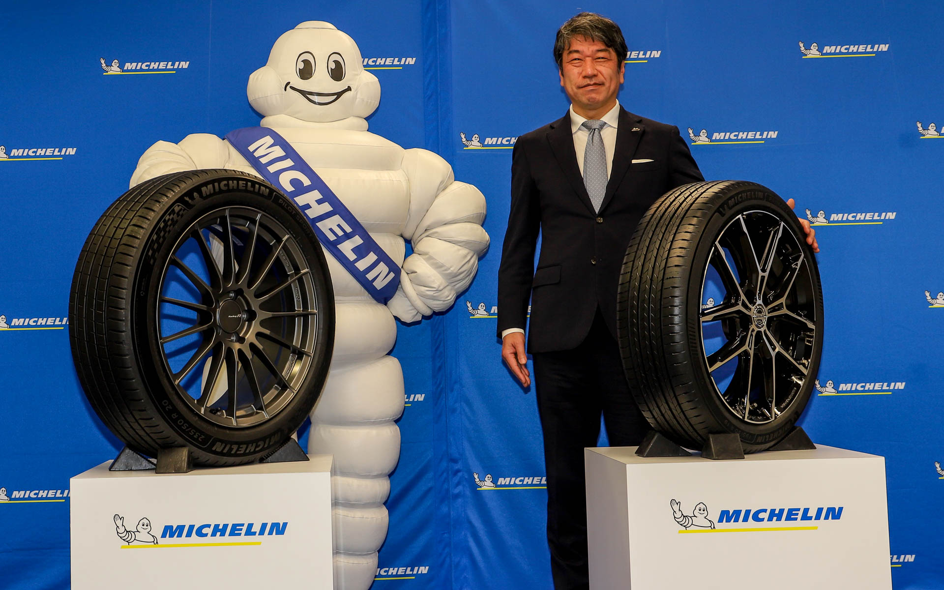 「パイロットスポーツ 5 エナジー」（左）と、「プライマシー 5 エナジー」（右）の発表会でフォトセッションを行なうミシュランマン（左）と日本ミシュランタイヤ株式会社 代表取締役社長 須藤元氏（右）