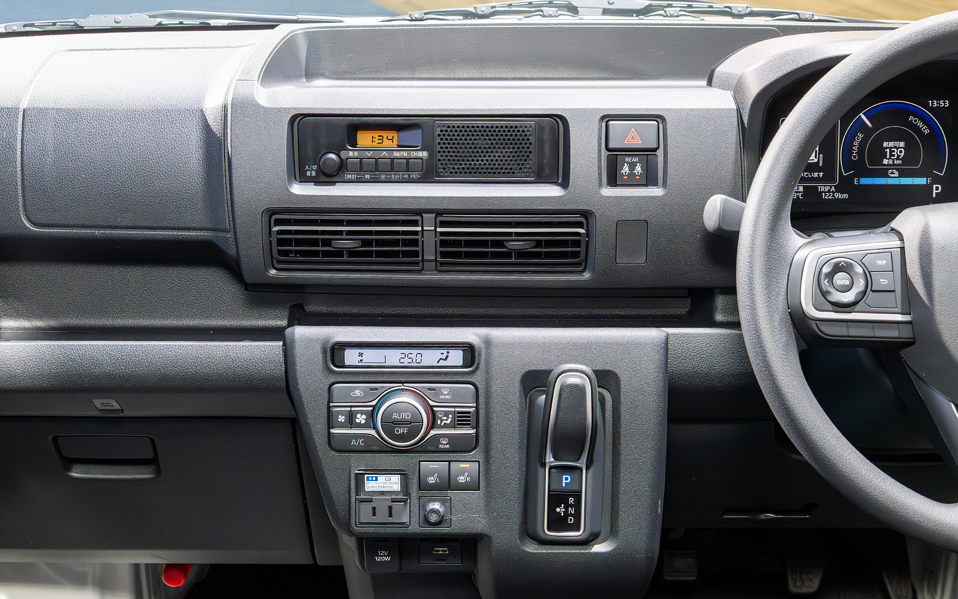 走行モードに切り替え用のエレクトリックシフトマジック操作レバーは先進的なデザイン。その横には、オートエアコンの操作パネル、シートヒーターのスイッチ、AC100V 1500Wのコンセントがある。その下には、アクセサリーソケットとUSB端子がある