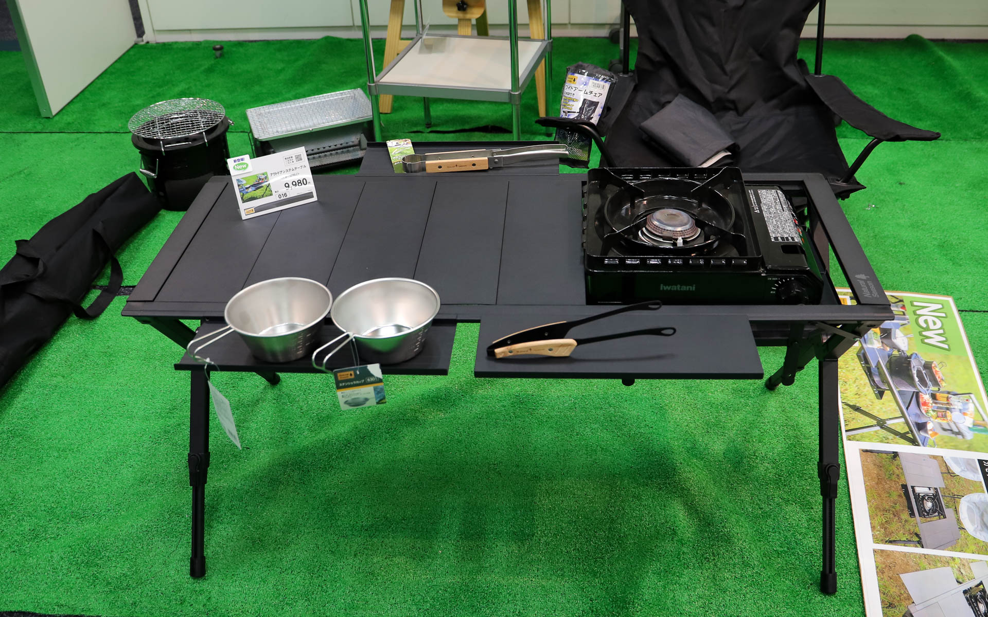 「アウトドアシステムテーブル」（9980円）。使うコンロや七輪のサイズに合わせてトレーの高さと位置が変更できるスグレモノ。天板は細かく取り外しでき、フレームに取り付けて拡張天板として利用可能。取り付けた天板は両面とも使えるので物が転がり落ちるのを防げる