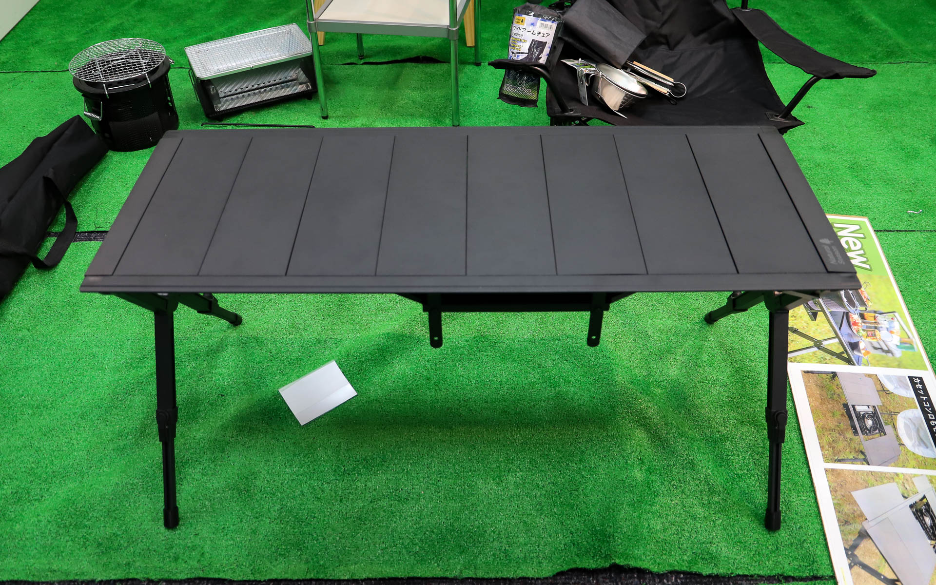 「アウトドアシステムテーブル」（9980円）。使うコンロや七輪のサイズに合わせてトレーの高さと位置が変更できるスグレモノ。天板は細かく取り外しでき、フレームに取り付けて拡張天板として利用可能。取り付けた天板は両面とも使えるので物が転がり落ちるのを防げる