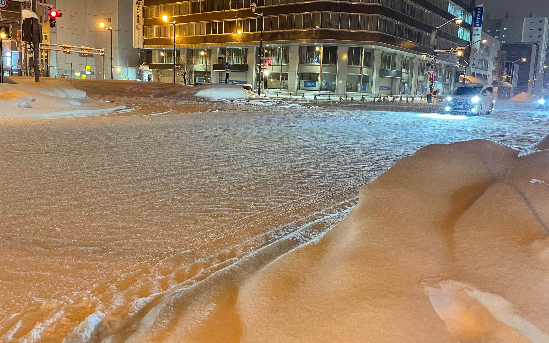 雪の夜の旭川の交差点。交差点はブラックバーンになりやすい。ときとしてこんなところをよく止まれるなと感じることがある