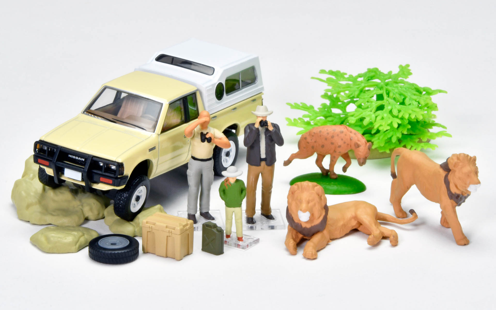 「#カースナップ32a サファリ4」の内容。「ニッサン トラック 4×4 キングキャブ シェル付」のほか、ライオン（座り）、ライオン（歩き）、ハイエナ、ツアーガイド、観光客（親）、観光客（子）、収納ボックス、スペアタイヤ、ジェリカン、低木、岩がセットとなる