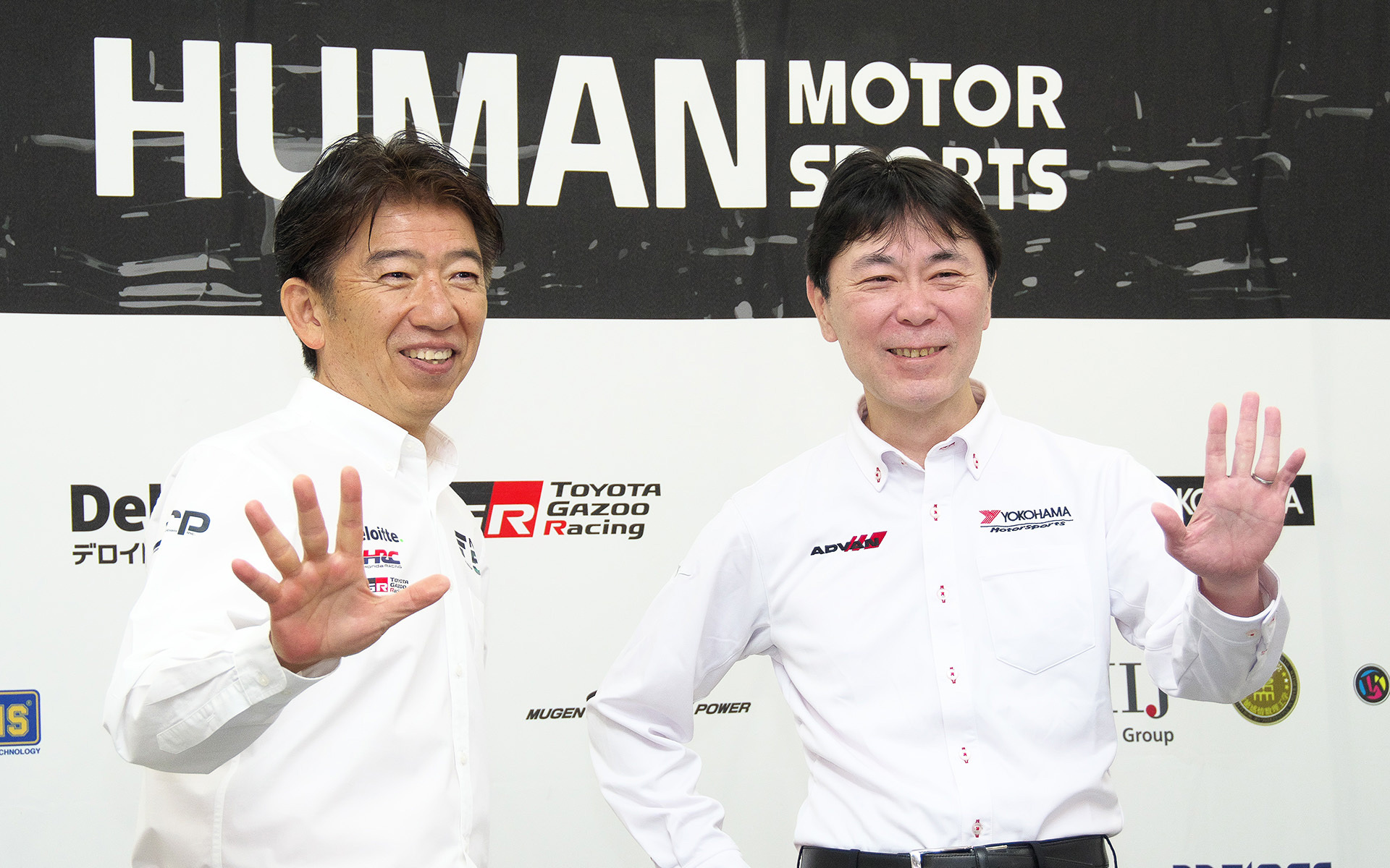 横浜ゴム株式会社 執行役員 タイヤ消費財商品企画本部長 塩入博之氏（右）と、株式会社日本レースプロモーション 代表取締役社長 上野禎久氏（左）。2030年まで5年の契約延長ということで、5を強調するポーズ