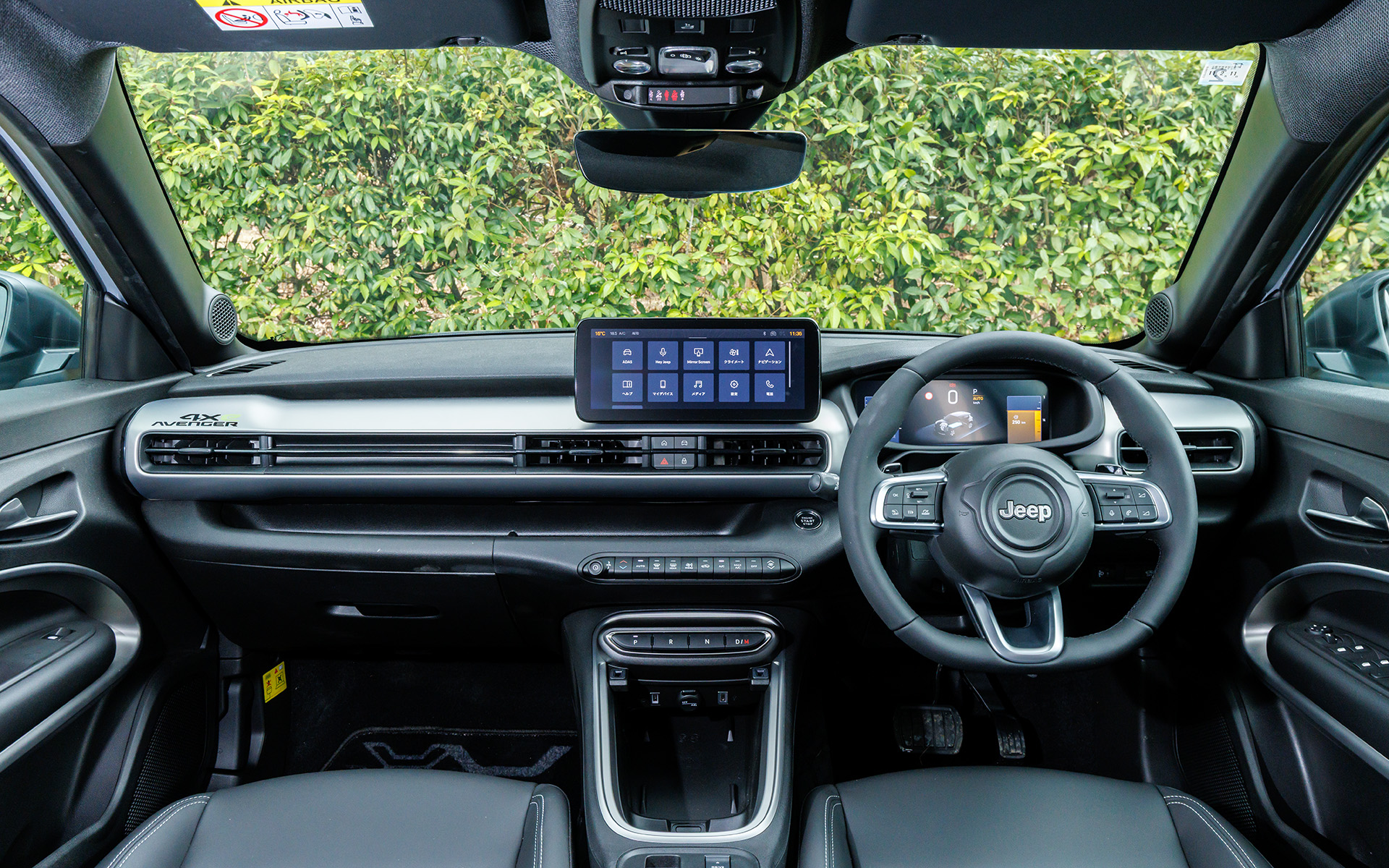 アベンジャー 4xe Hybridのインテリア。シフトはスイッチ式。テクノレザーステアリングホイールを採用し、スポーク付け根の右側にはヒルディセントコントロールのスイッチを配置する