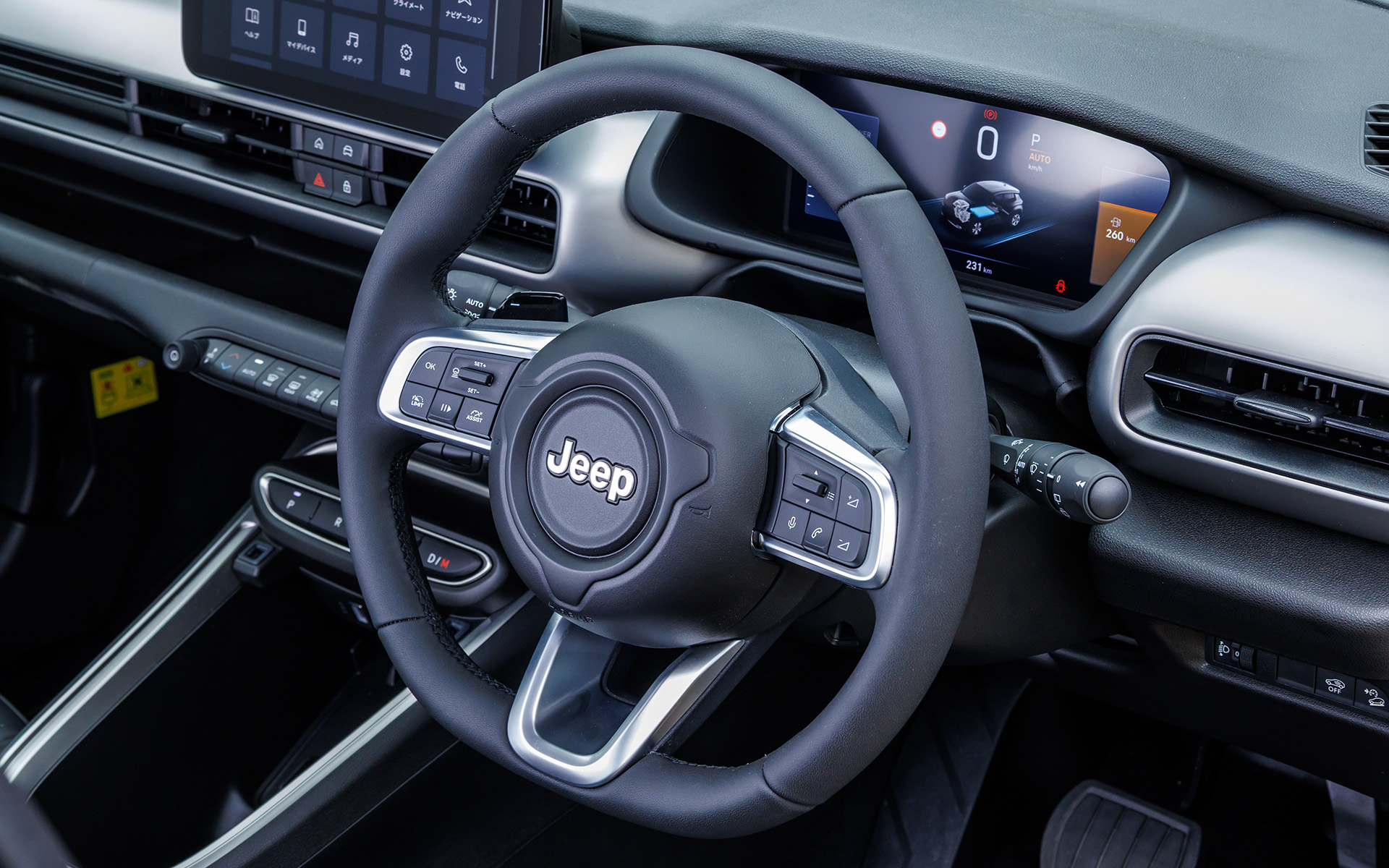 アベンジャー 4xe Hybridのインテリア。シフトはスイッチ式。テクノレザーステアリングホイールを採用し、スポーク付け根の右側にはヒルディセントコントロールのスイッチを配置する