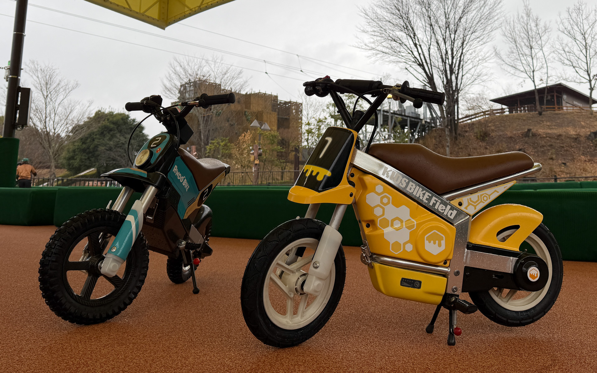 「キッズバイクフィールド」のバイク（写真右）。養蜂場をイメージし、ハチミツの要素を取り入れたデザインで、全体的に黄色をベースカラーとしたデザインとなっている