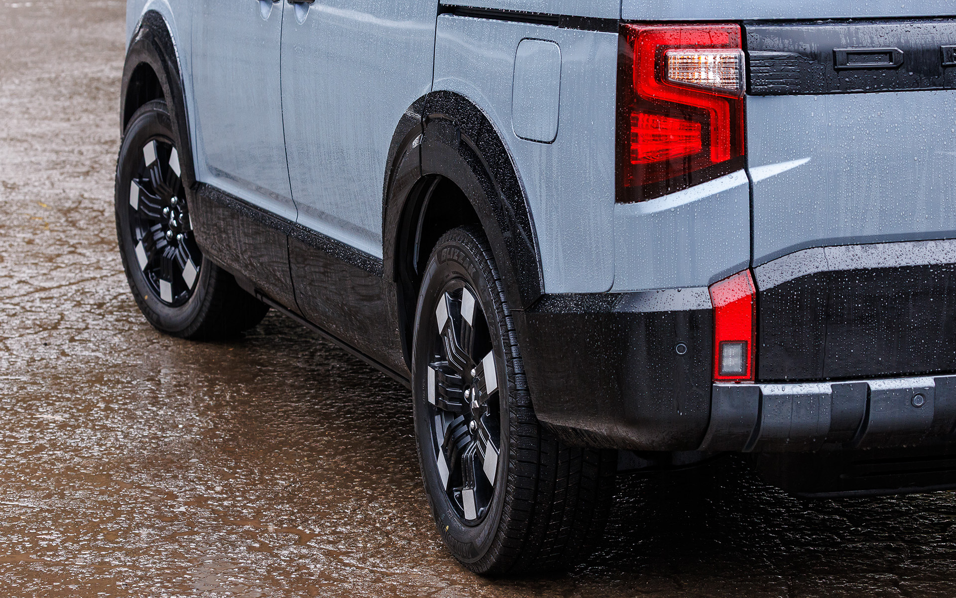 エクステリアではフロントグリルとフロントバンパーをシンプルで立体感のある力強いデザインにするとともに、リアは左右につながっていたテールランプから中央に「DELICA」ロゴを配置するスタイルに変更。また、ボディサイドにはワイドで安定感のある足まわりと高い走破性を想起させるホイールアーチモールを新採用し、力強さとギア感を高めた。加えて新デザインの18インチアルミホイールも採用する