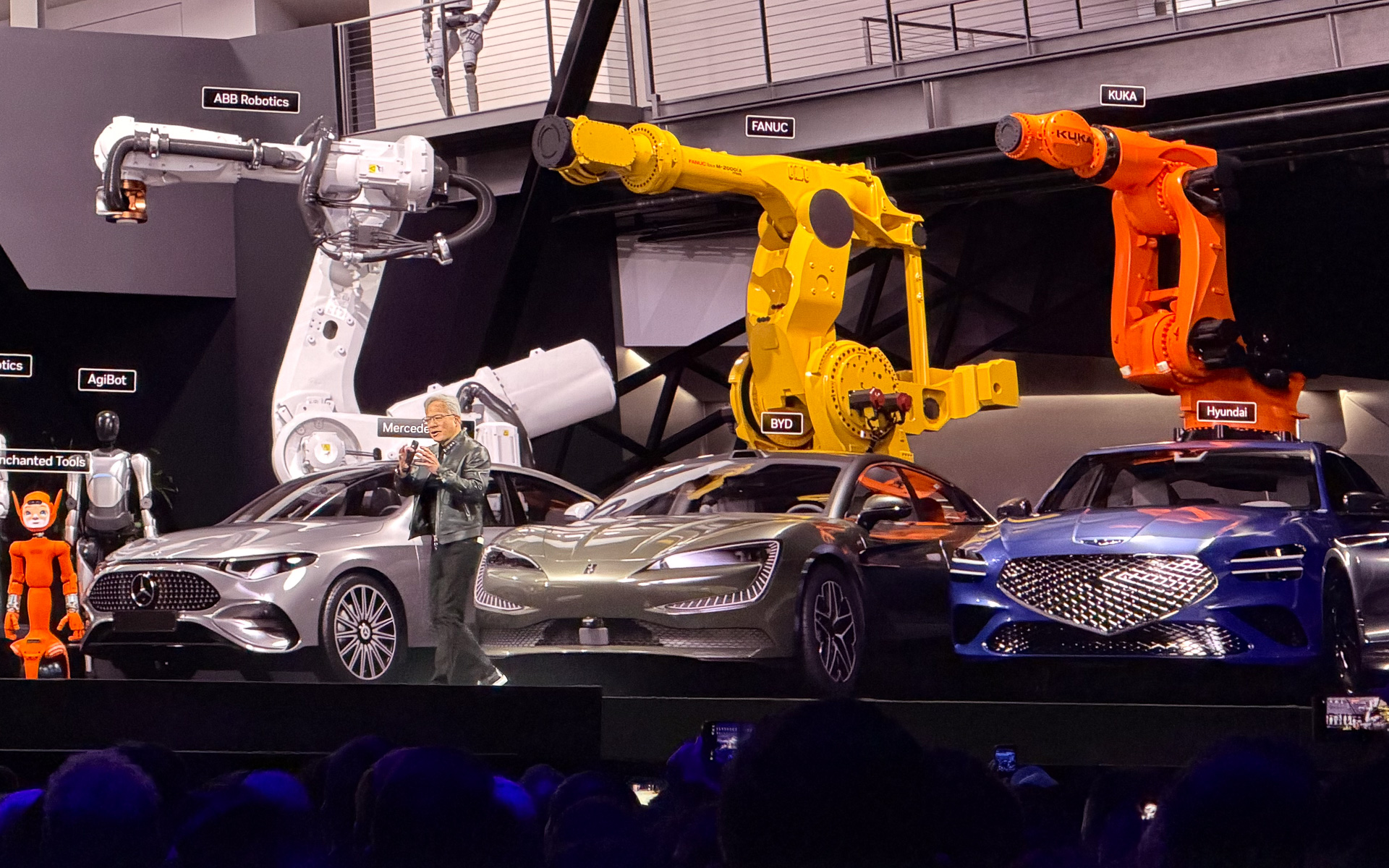 日産がパートナーとなったことなどを発表するNVIDIA 創業者兼CEO ジェンスン・フアン氏。後方にはメルセデス、BYD、ヒョンデのクルマが並ぶ