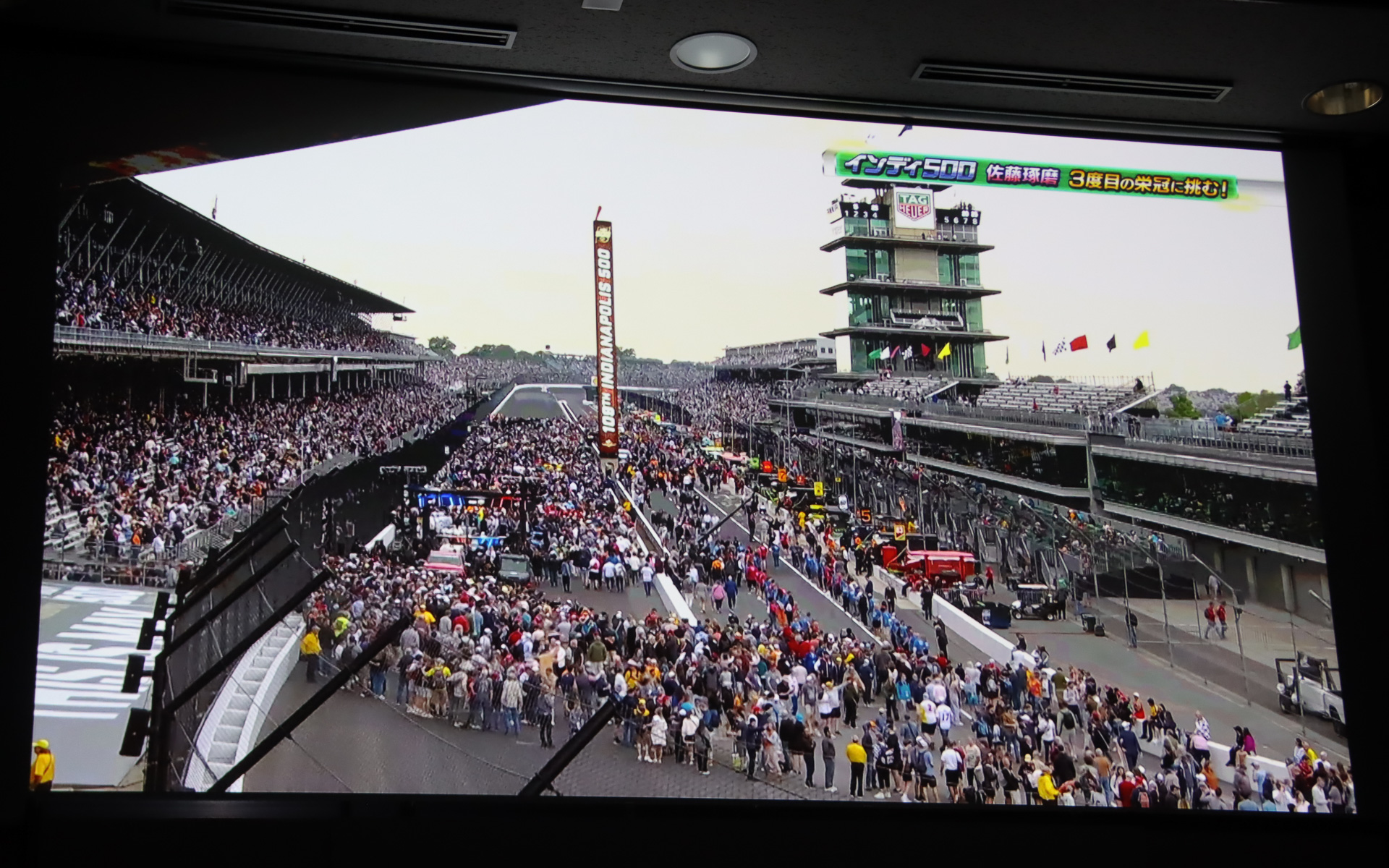 ステージ上のスクリーンで上映されたインディ500 2025年大会のダイジェスト。予選2番手からのスタートで51周をトップ走行したが、一斉にピットインしたタイミングで佐藤琢磨選手は自分のピットスペースで停止できず、大きく順位を落として9位フィッシュとなった