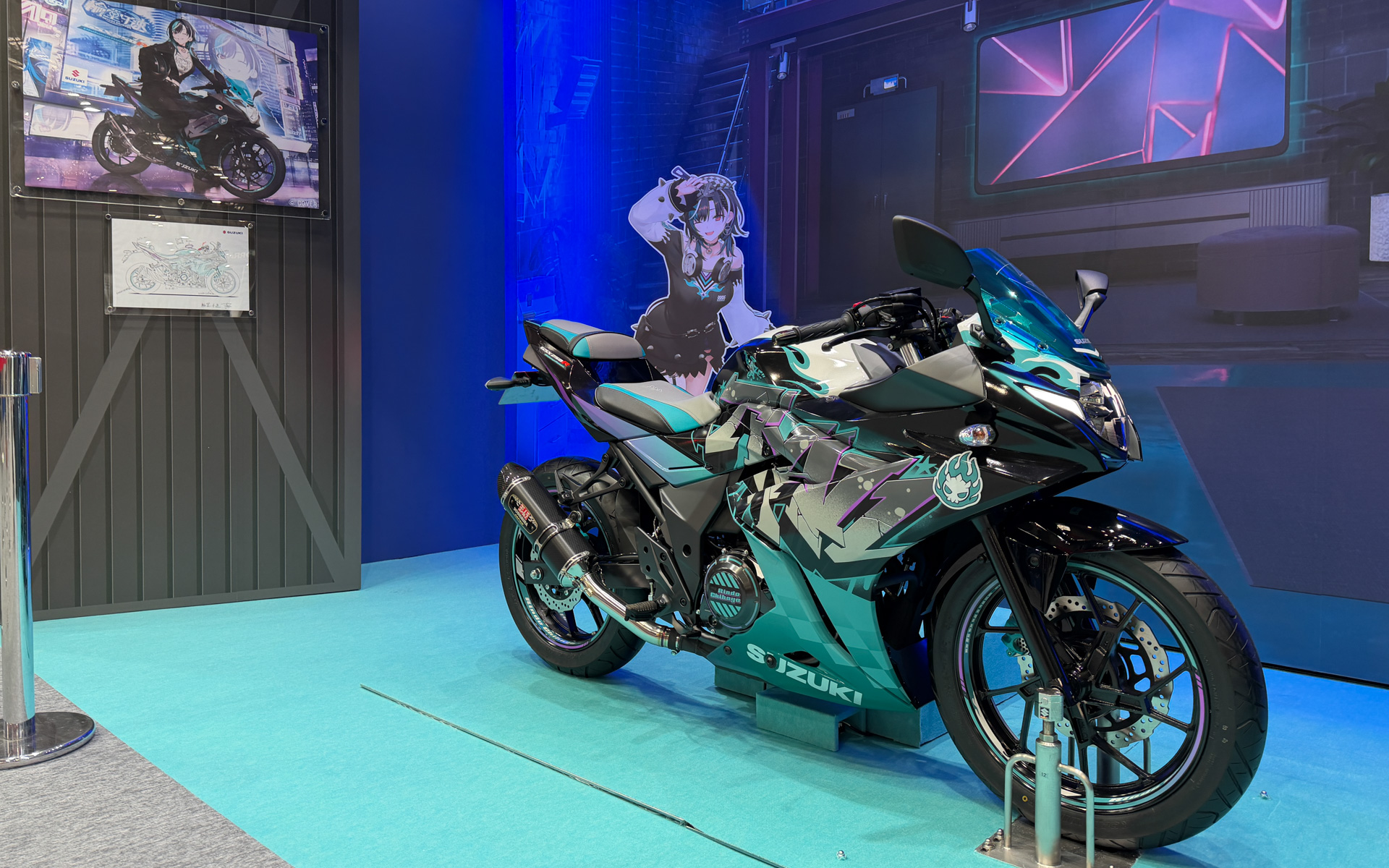バーチャルYouTuber輪堂千速さんと共同でデザインしたコラボレーションバイク「GSX250R [Chihaya Remix]」（非売品）をまたがり可能な状態で展示している