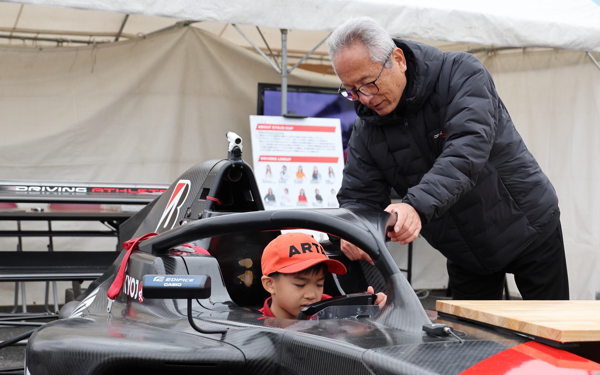 KYOJOのフォーミュラーカーへの乗車体験のサポートをする関谷正徳氏