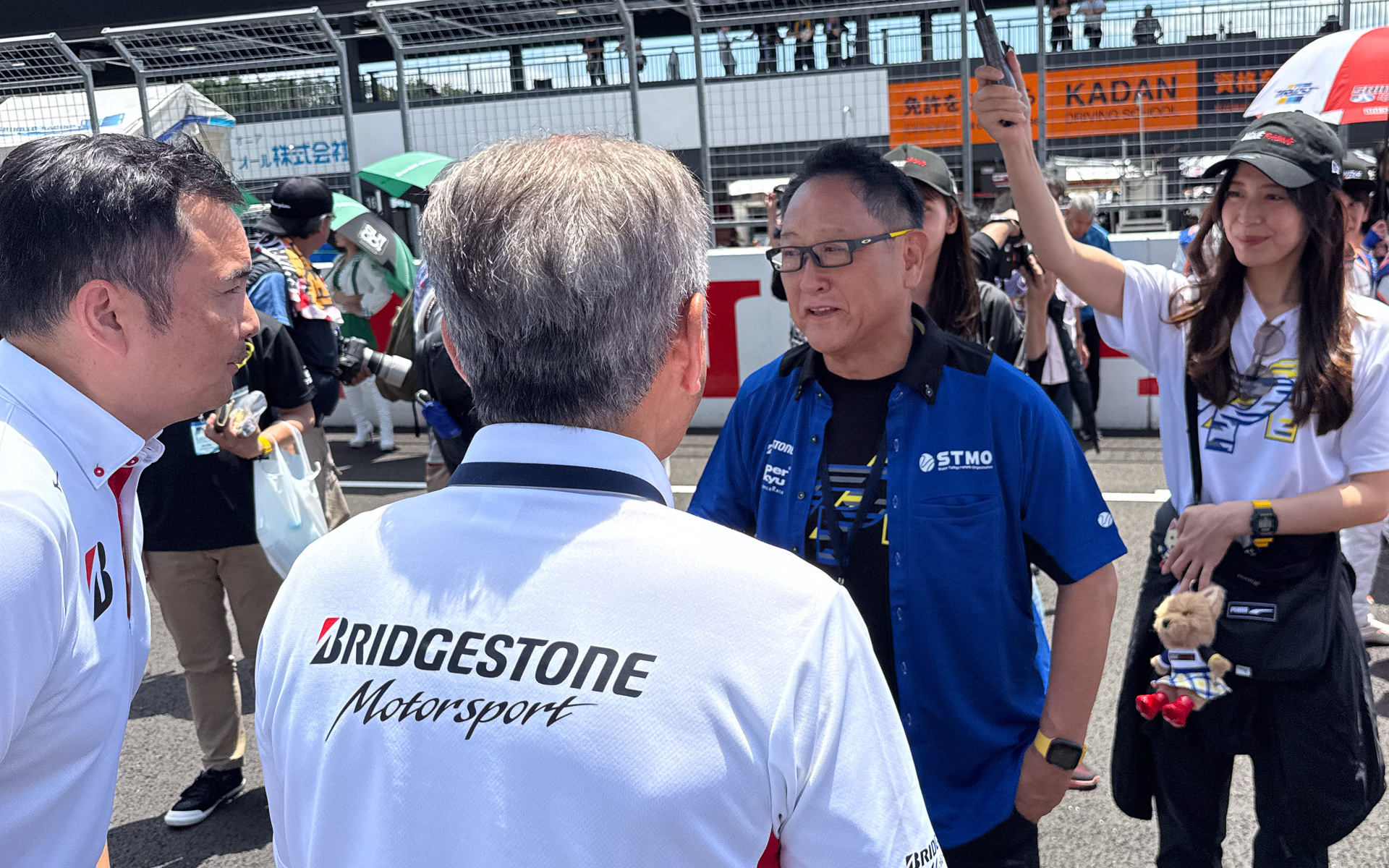 2025年7月、スーパー耐久SUGO戦で視察を行なう豊田章男会長。Tシャツはルーキーレーシングだが、シャツはスーパー耐久未来機構