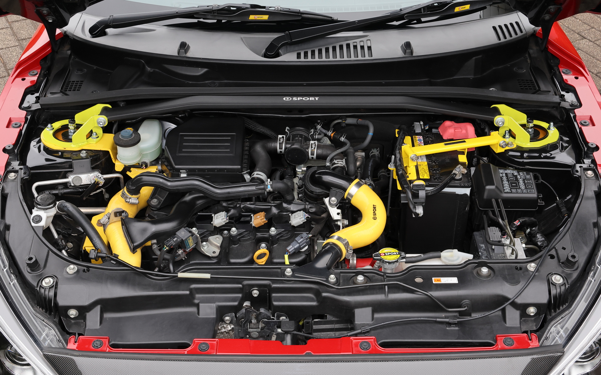 エンジンルーム内は新製品の「タワーバー」のほか、「スーパークーリングラジエター」「レーシングインタークーラー」「ブレーキマスターシリンダーストッパー」「インテークホースキット」「ラジエターキャップ（1.3kgf）」「スーパーラジエターホース」「バッテリークランプ」を装着