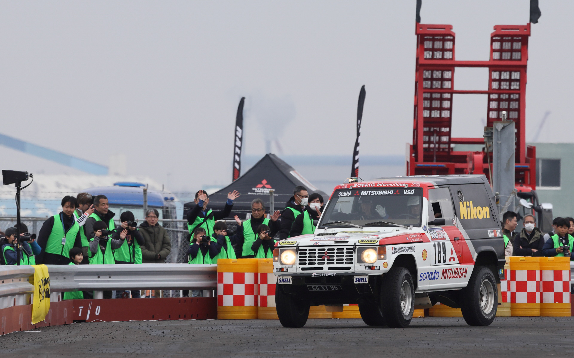 黄色いNikonのロゴが鮮やかなパジェロは1985年のパリダカ総合優勝車。翌年F1でコンストラクターズタイトルを獲得したウィリアムズ・ホンダFW11には白地に赤いCanonのロゴが大きく描かれていた