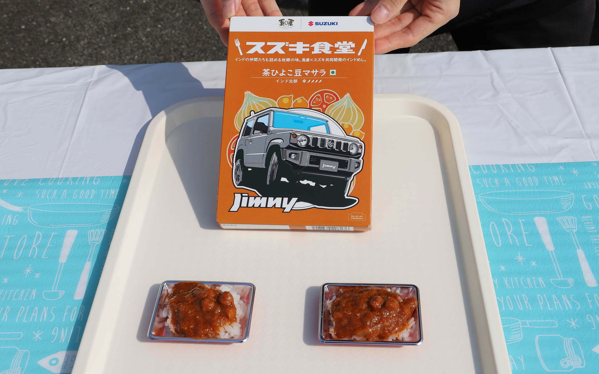 スズキオリジナルのレトルトカレーの試食が行なわれた。ジムニーがパッケージに描かれた「茶ひよこ豆マサラ」は全5種類の中で最も辛いカレーで、ひよこ豆の優しい味がアクセント。試食は11時からと13時からの2回、各150名分が用意されたものの、あっという間に配布終了となっていた