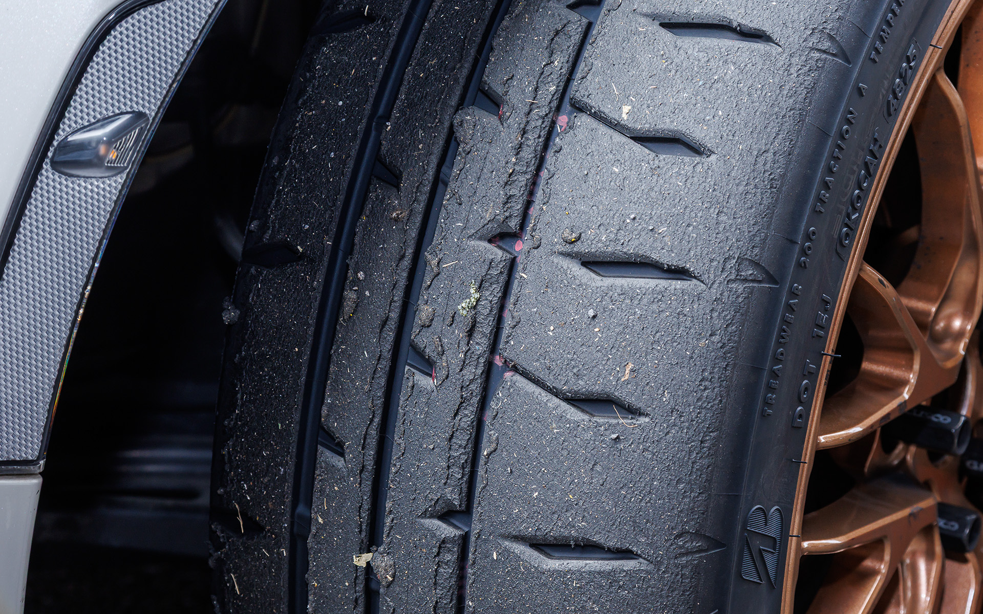 写真上が「RE-71RS」、下が「RE-71RZ」の走行後の状況。「RE-71RZ」が均一に溶けているのに対し、「RE-71RS」ではアウト側の細い主溝周辺で偏摩耗が見て取れる