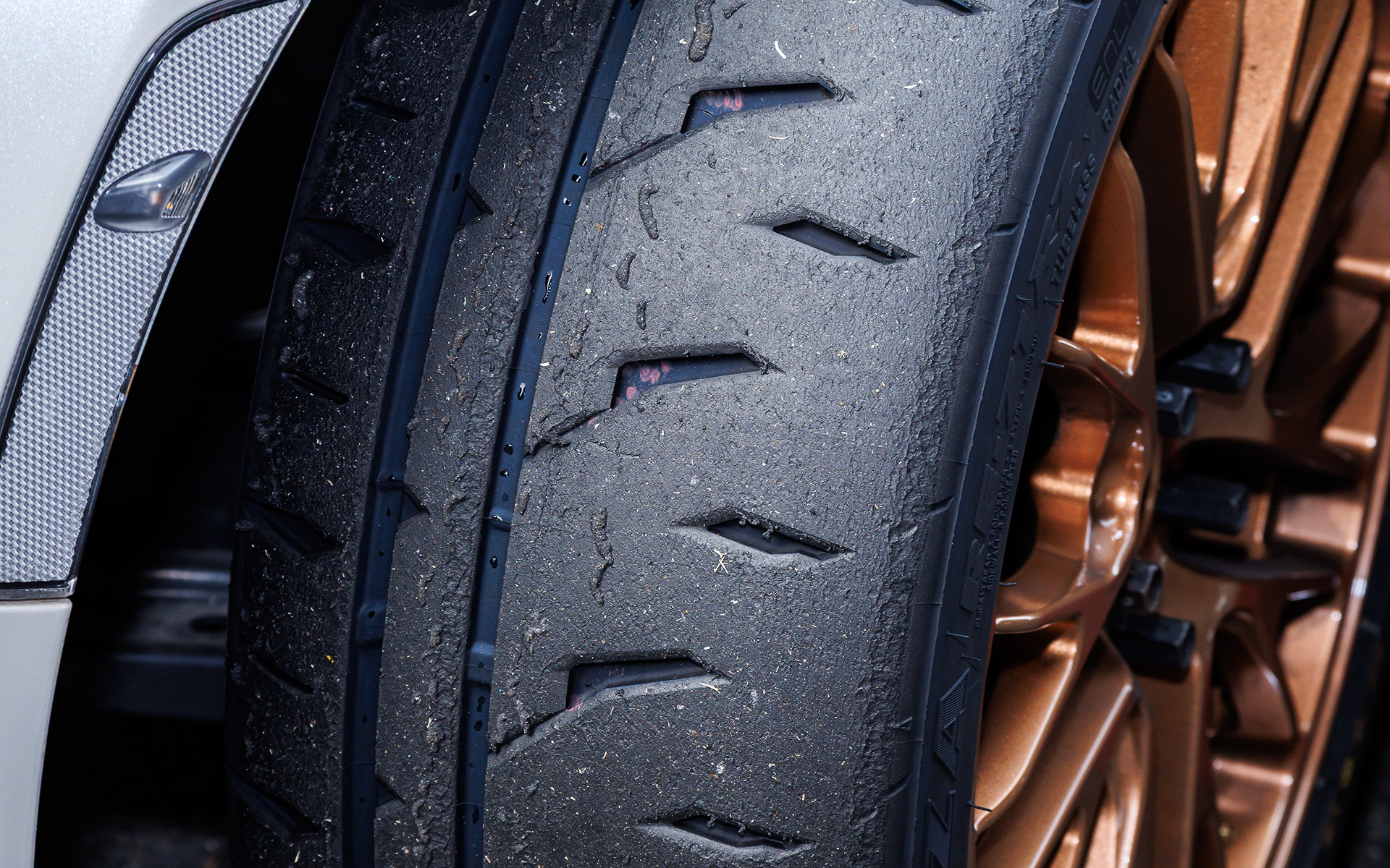 写真上が「RE-71RS」、下が「RE-71RZ」の走行後の状況。「RE-71RZ」が均一に溶けているのに対し、「RE-71RS」ではアウト側の細い主溝周辺で偏摩耗が見て取れる