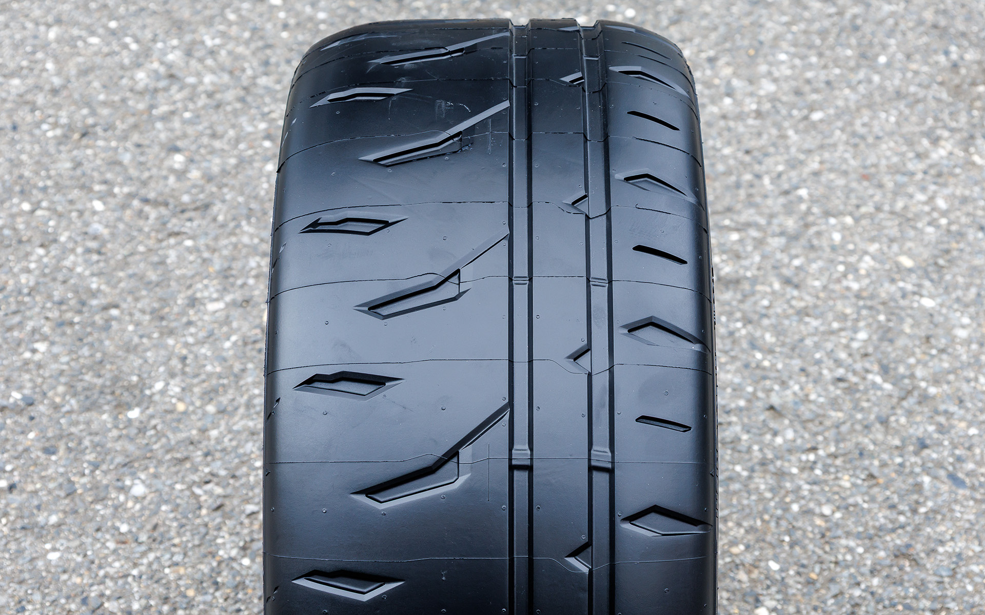 搭載技術としては「ナノプロ・テック」技術を活用し、シリカとポリマーを最適配合した新開発ゴムを採用。従来品以上にゴムが路面にしっかり食い込みグリップを発揮することで、ドライ・ウエット路面で優れた走行性能を実現。また、接地面積と溝設定を最適化した新開発のパターンを採用。ブロック剛性を高めるスリックショルダーを採用し、イン側に排水性を高めるワイドストレートグルーブを配置することで、グリップ力とサーキットでの耐摩耗性を高次元で両立している