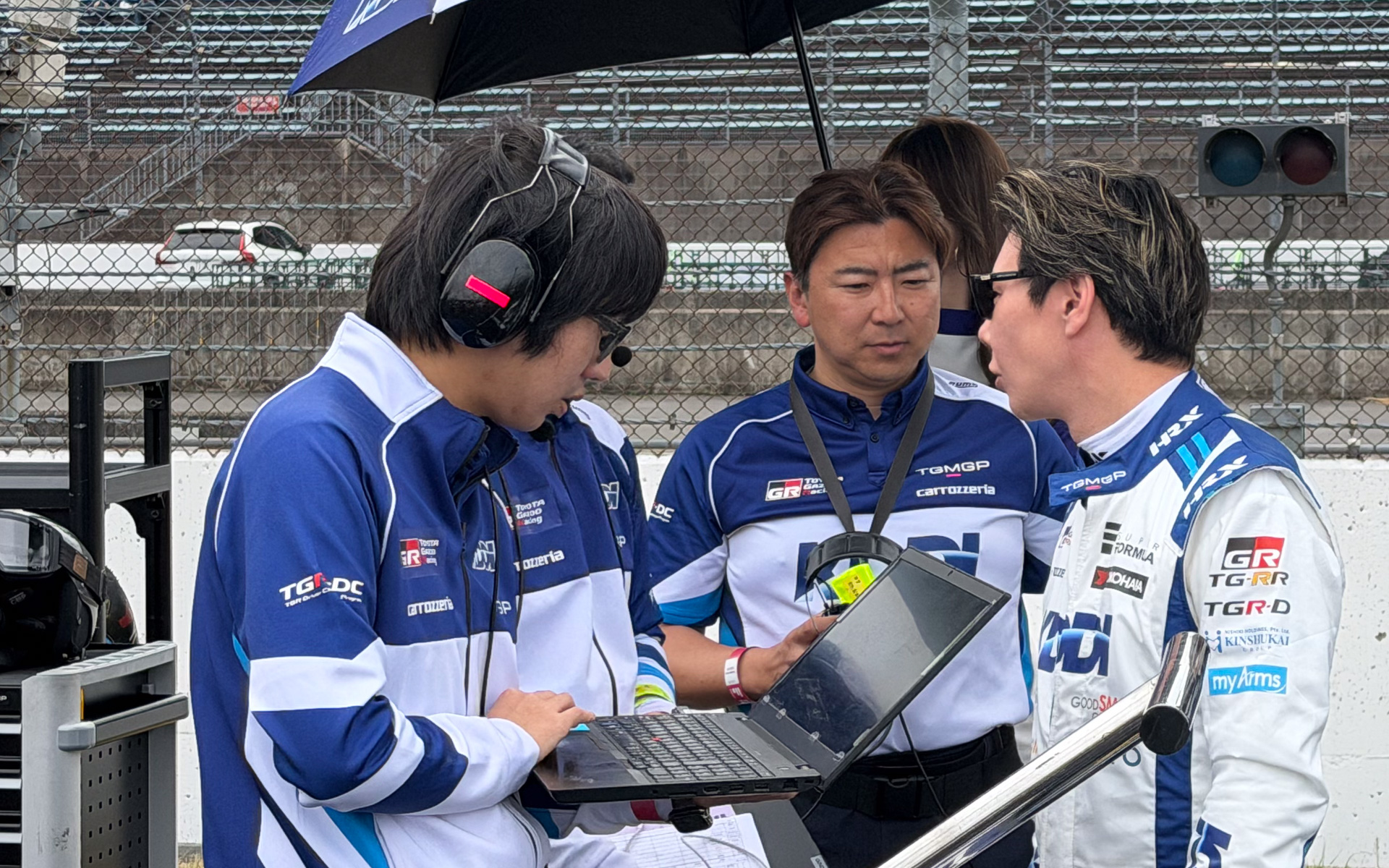 片岡龍也監督（中央）と何やら話をする小林可夢偉選手