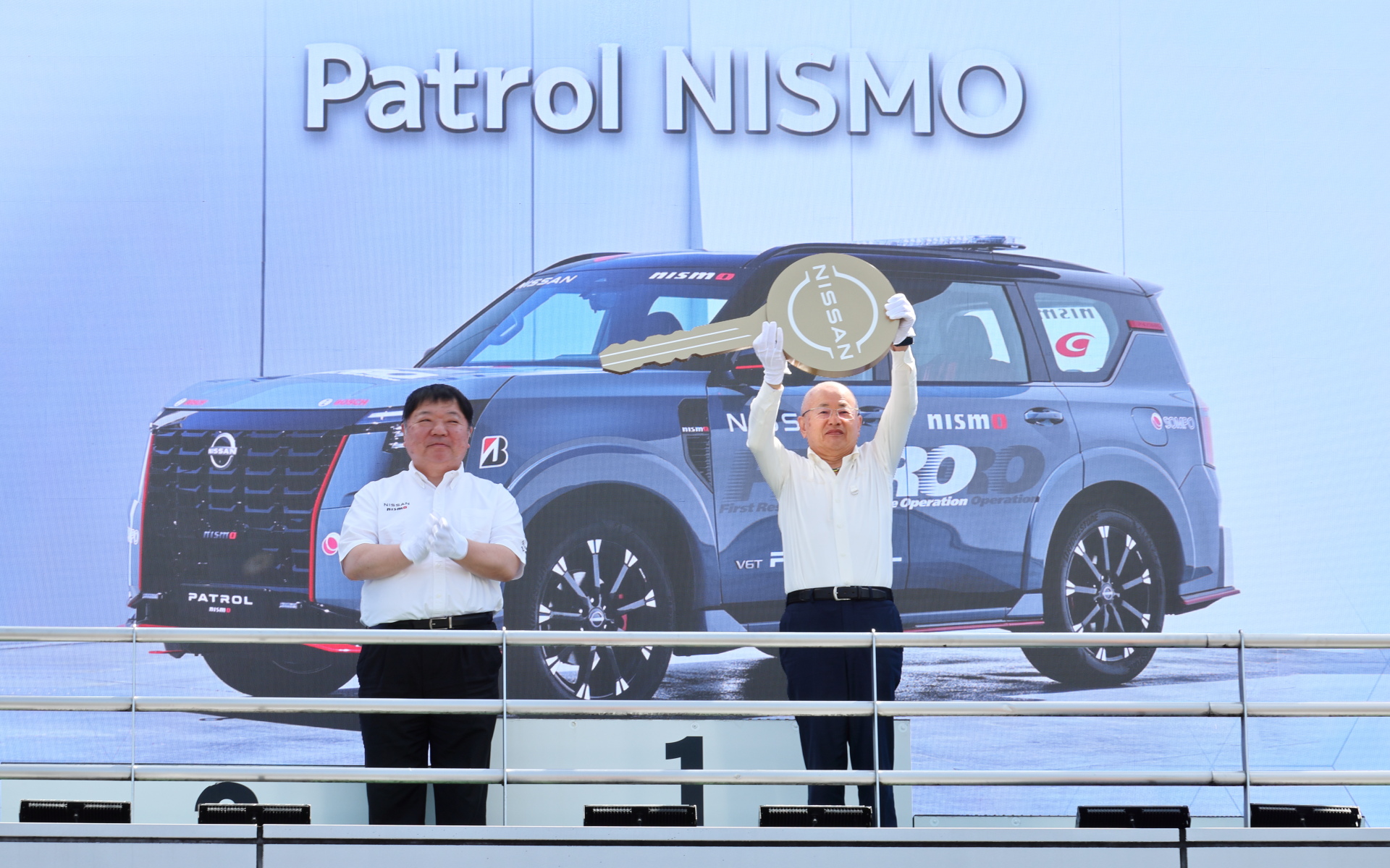 日産モータースポーツ＆カスタマイズ株式会社 社長兼CEO 真田裕氏（左）から、株式会社GTアソシエイション 坂東正明代表にFRO車両「パトロール NISMO」が贈呈された