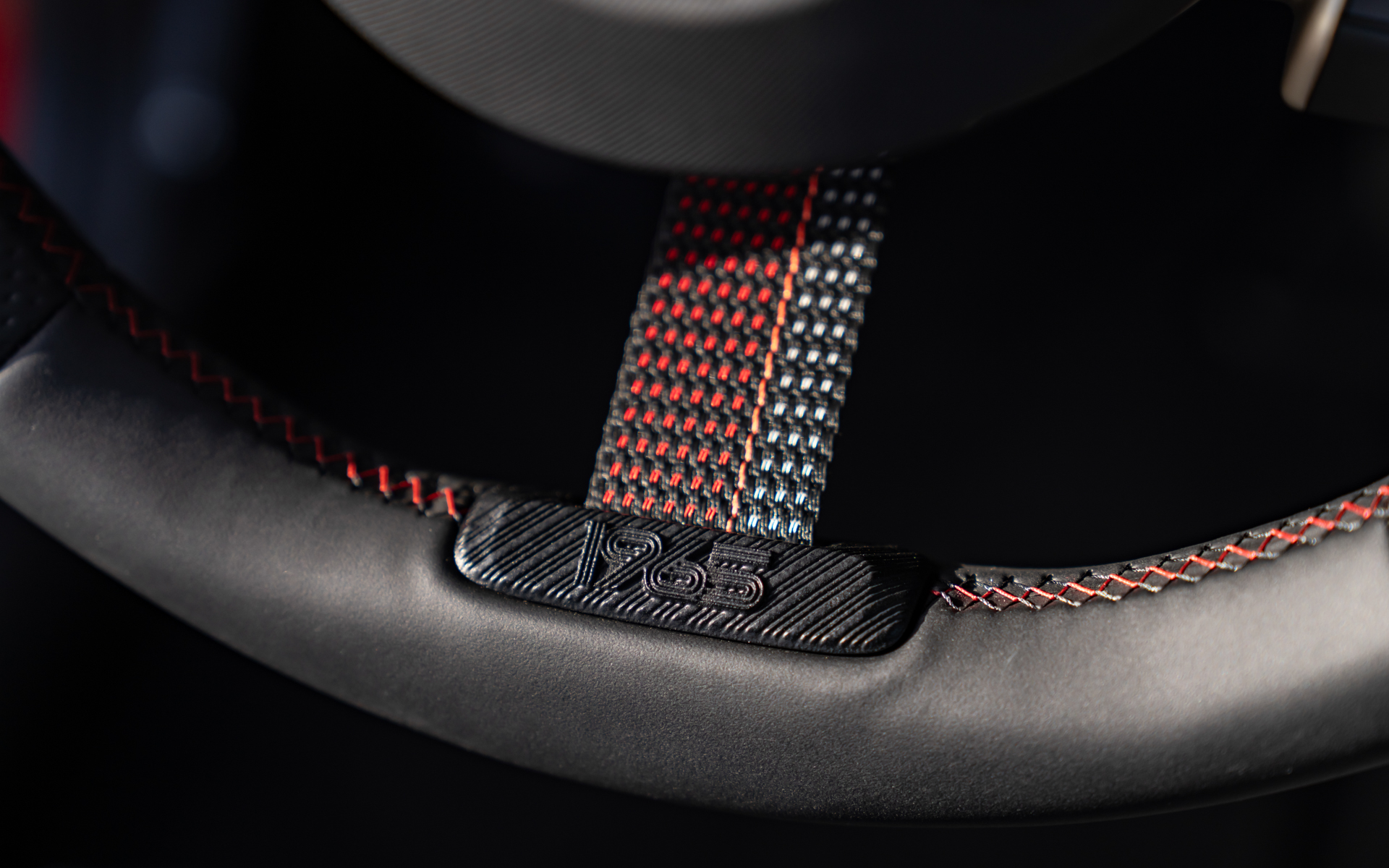 ステアリングの6時の位置と、収納ボックスにも「1965」の文字が入るほか、キーケースにはゼッケンの「52」があしらわれる