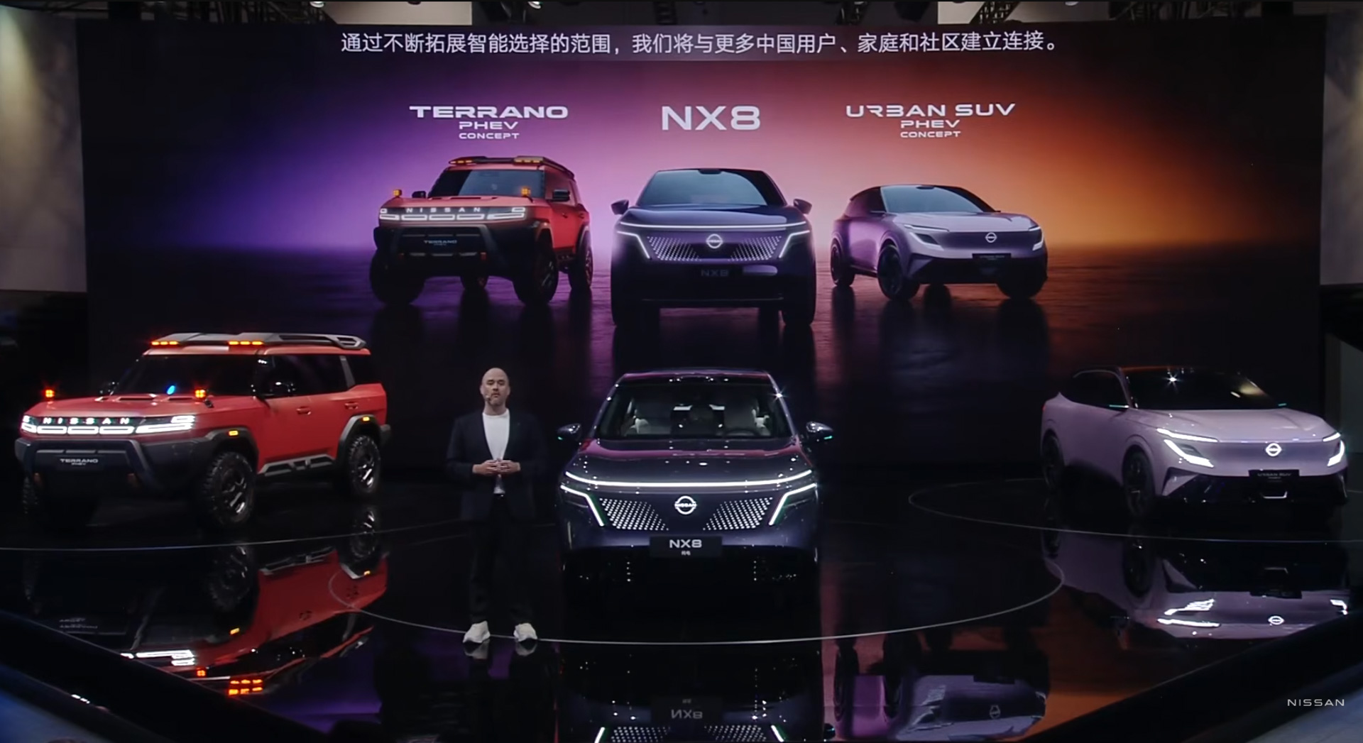 「北京モーターショー2026」会場に登壇したイヴァン・エスピノーサ社長。ステージ上には「テラノPHEVコンセプト」「アーバンSUV PHEVコンセプト」「NX8」が展示された