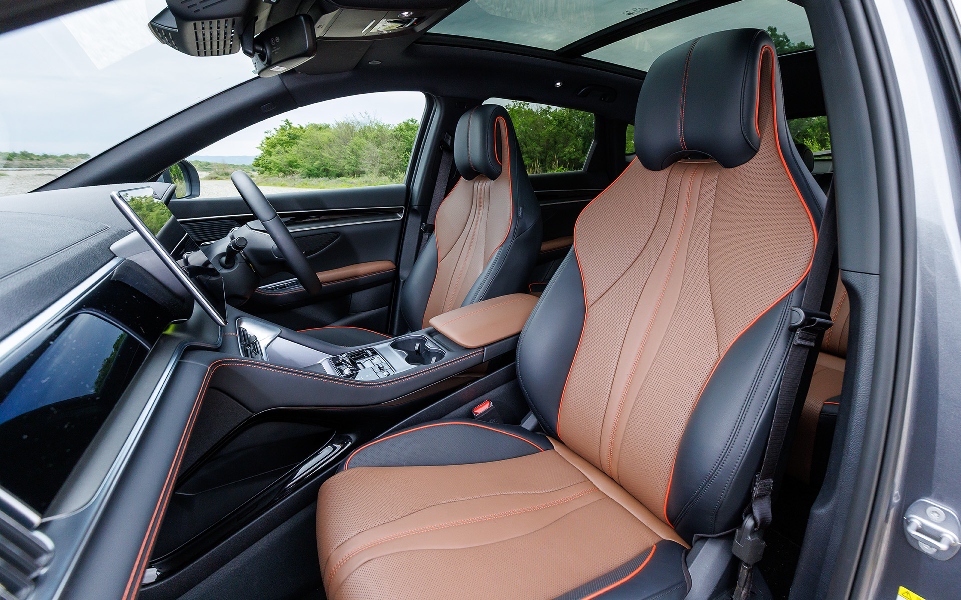 インテリアは深みのあるブラックを基調とし、ブラウンのアクセントとアンビエントライトを配してモダンなデザインに仕上げた。スポーツシートの前席にはヒーターとベンチレーションを備え、センターコンソールにはクリスタルを思わせる電動シフトレバーや2基のワイヤレス充電などを配置し、上質感と機能性を両立させている